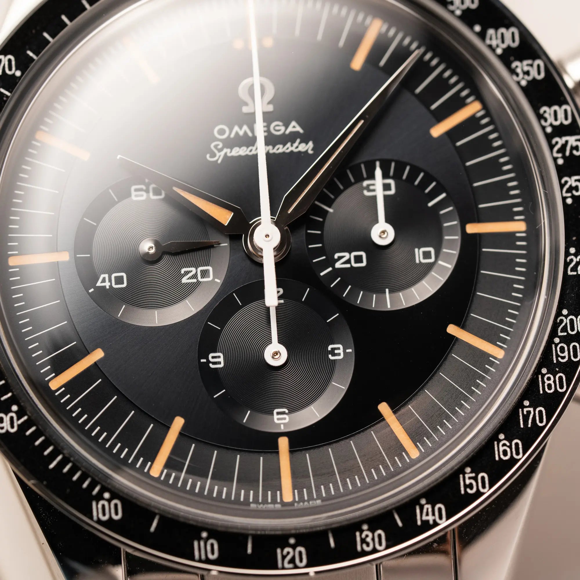 Detailaufnahme zeigt den Uhrenkopf der Omega Speedmaster FOIS der Referenz 310.30.40.50.06.001 mit dem dunkelblauen Zifferblatt mit dunkel-beigen Indizes im Vintage-Look und einem vom Standard-Modell abgeänderten Stahl-Armband, was beides an das klassische Speedy-Modell erinnert