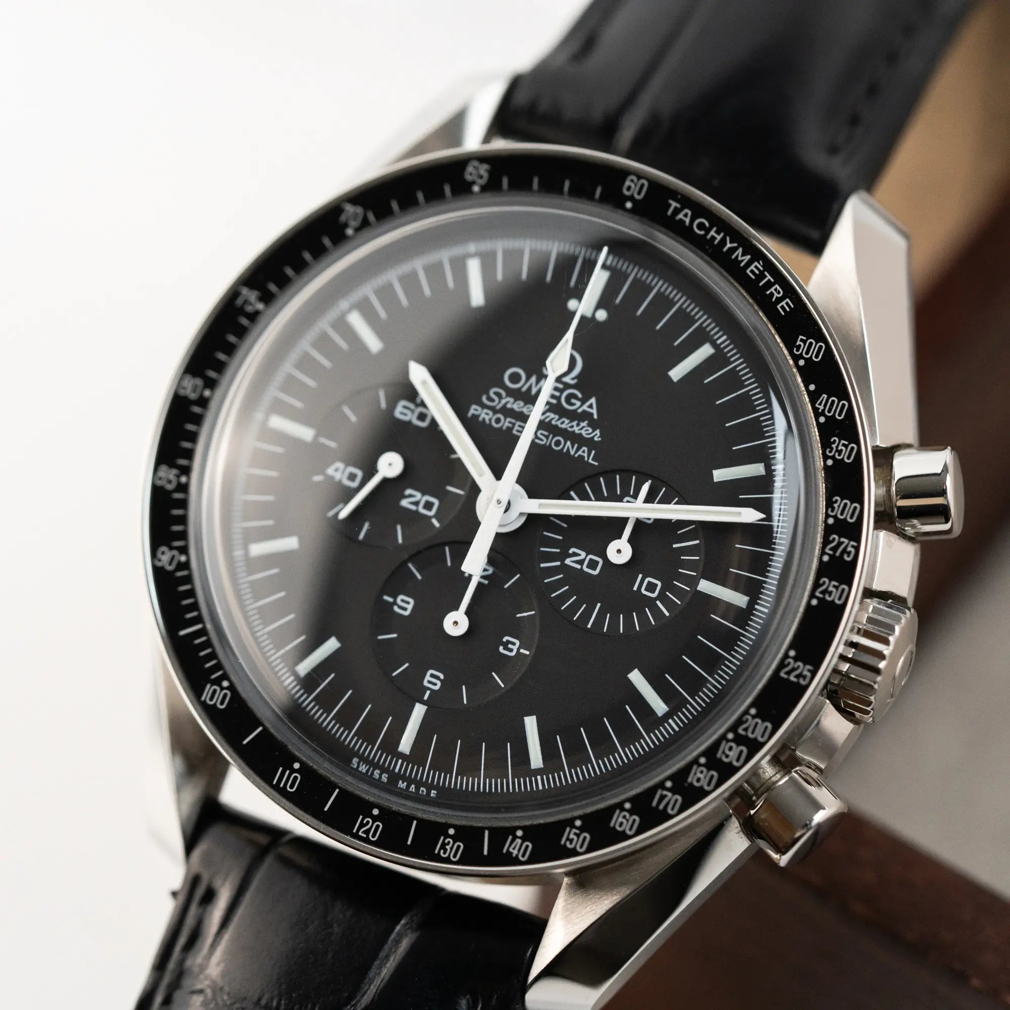 Detailaufnahme der Omega Speedmaster Moonwatch am schwarzen Lederband