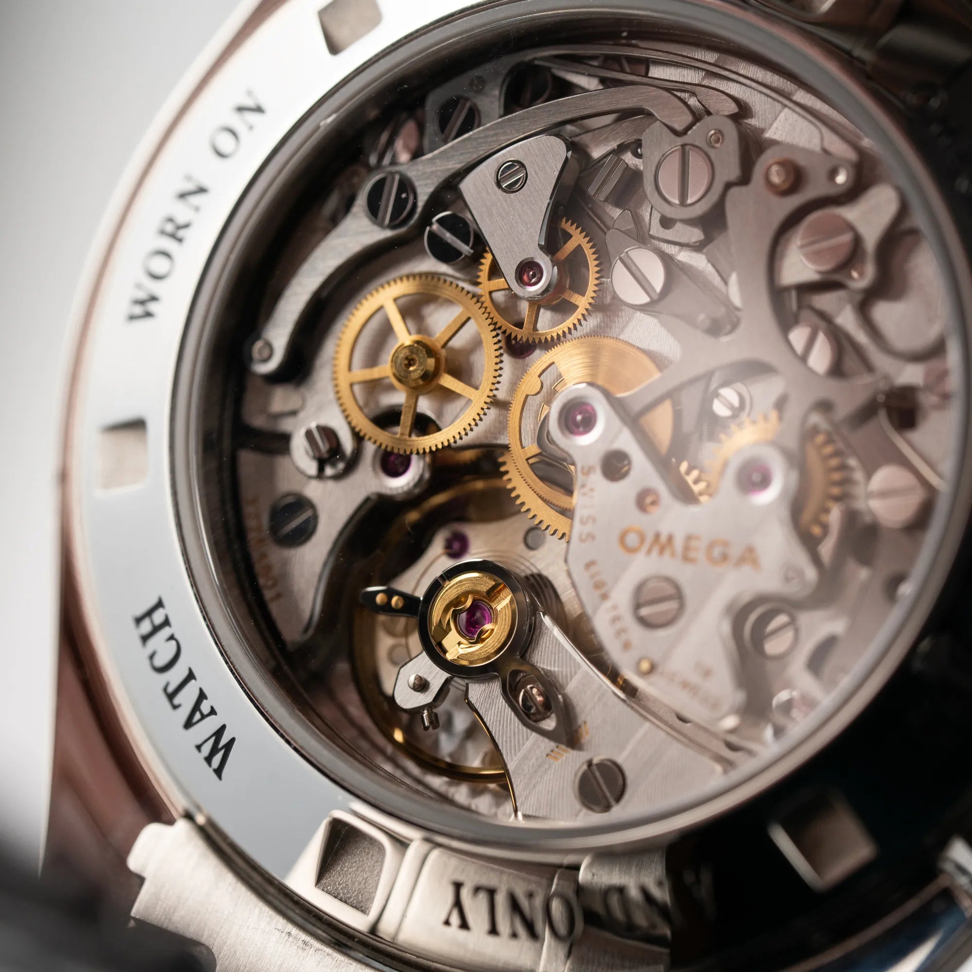 Detailaufnahme des Handaufzug-Chronographen-Uhrwerks durch den Glasboden der Omega Speedmaster Professional Moonwatch 311.30.42.30.13.001 mit einem braunen Zifferblatt