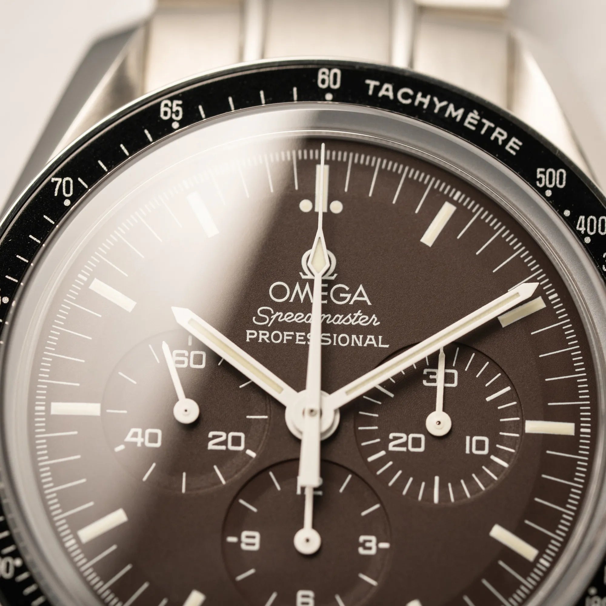 Detailaufnahme der Omega Speedmaster Professional Moonwatch 311.30.42.30.13.001 mit einem braunen Zifferblatt