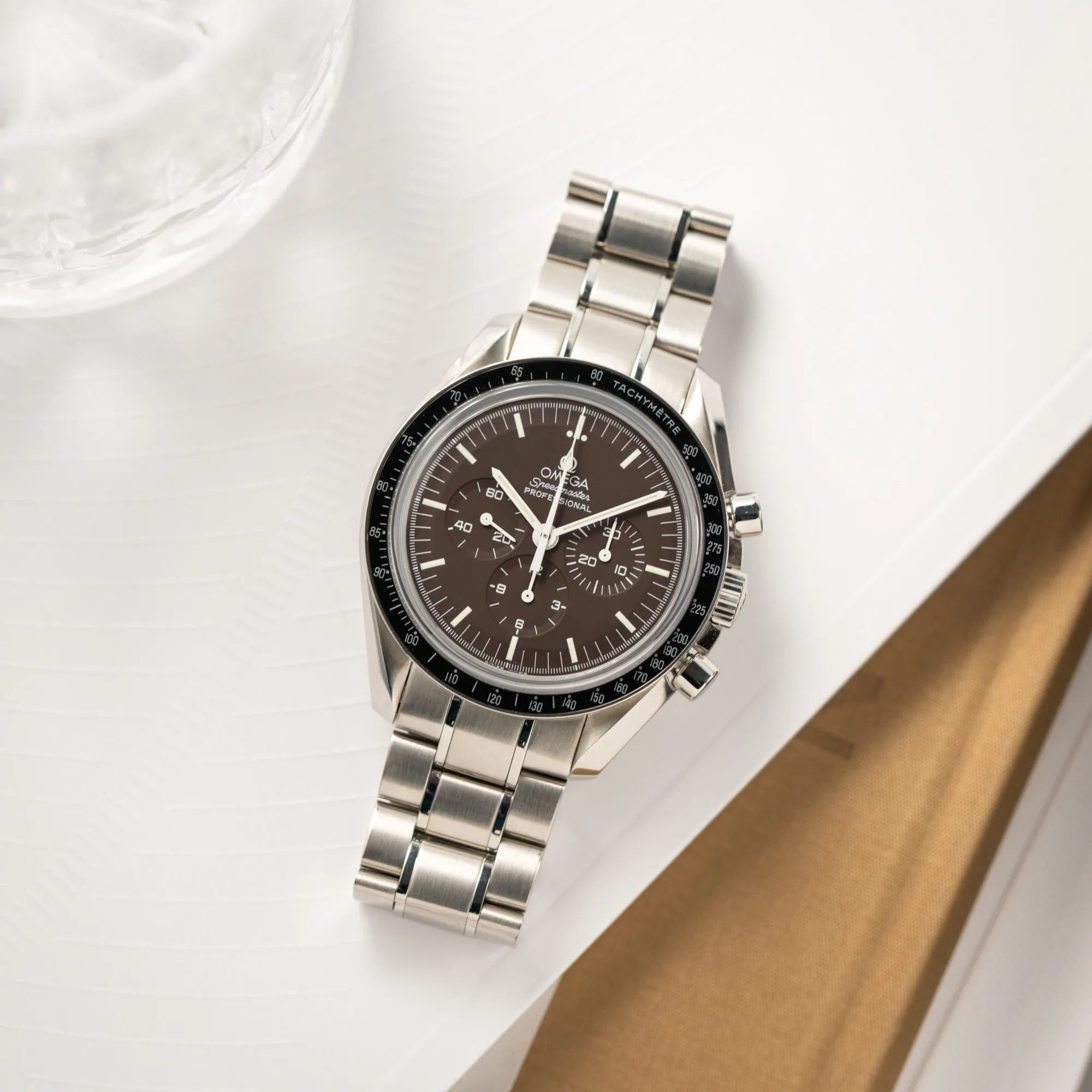Produktfotografie der Omega Speedmaster Professional Moonwatch 311.30.42.30.13.001 mit einem braunen Zifferblatt