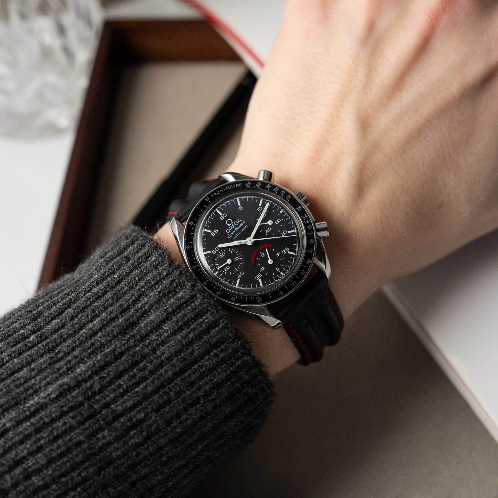 Mann trägt die Omega Speedmaster Reduced AC Mailand 100th Anniversary Limited Edition an seinem Handgelenk