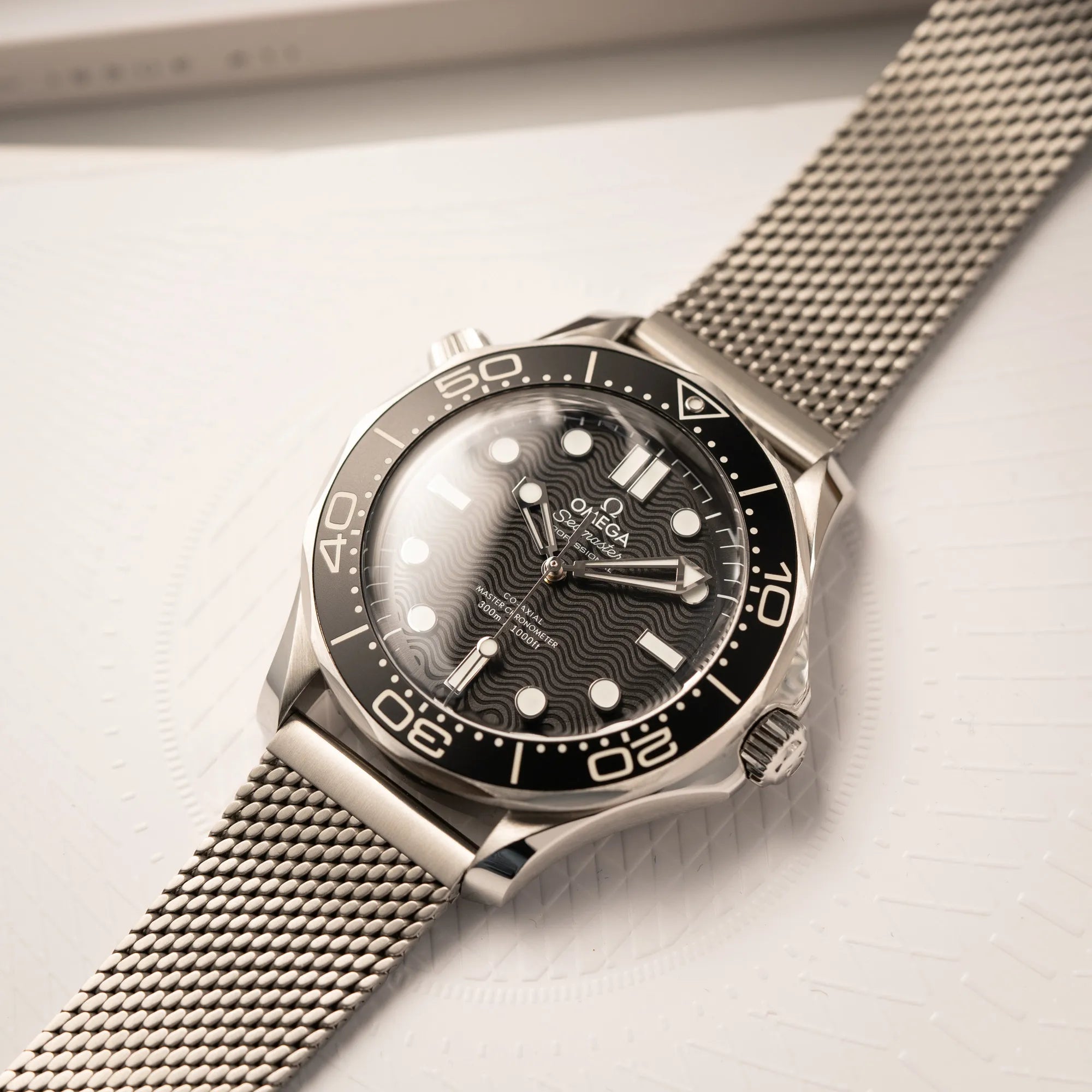 Produktfotografie der Omega Seamaster 300M Diver 210.30.42.20.01.010 mit dems schwarzen Zifferblatt im Wellen-Design am Milanese-Edelstahl-Armband