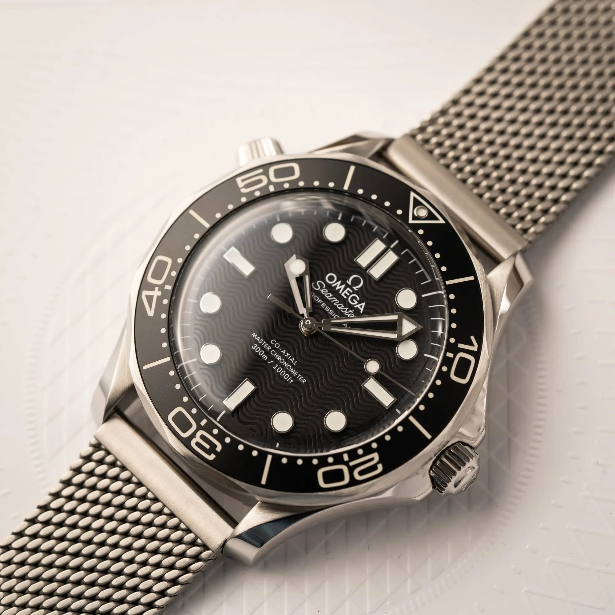 Detailaufnahme der Omega Seamaster 300M Diver 210.30.42.20.01.010 mit dems schwarzen Zifferblatt im Wellen-Design am Milanese-Edelstahl-Armband