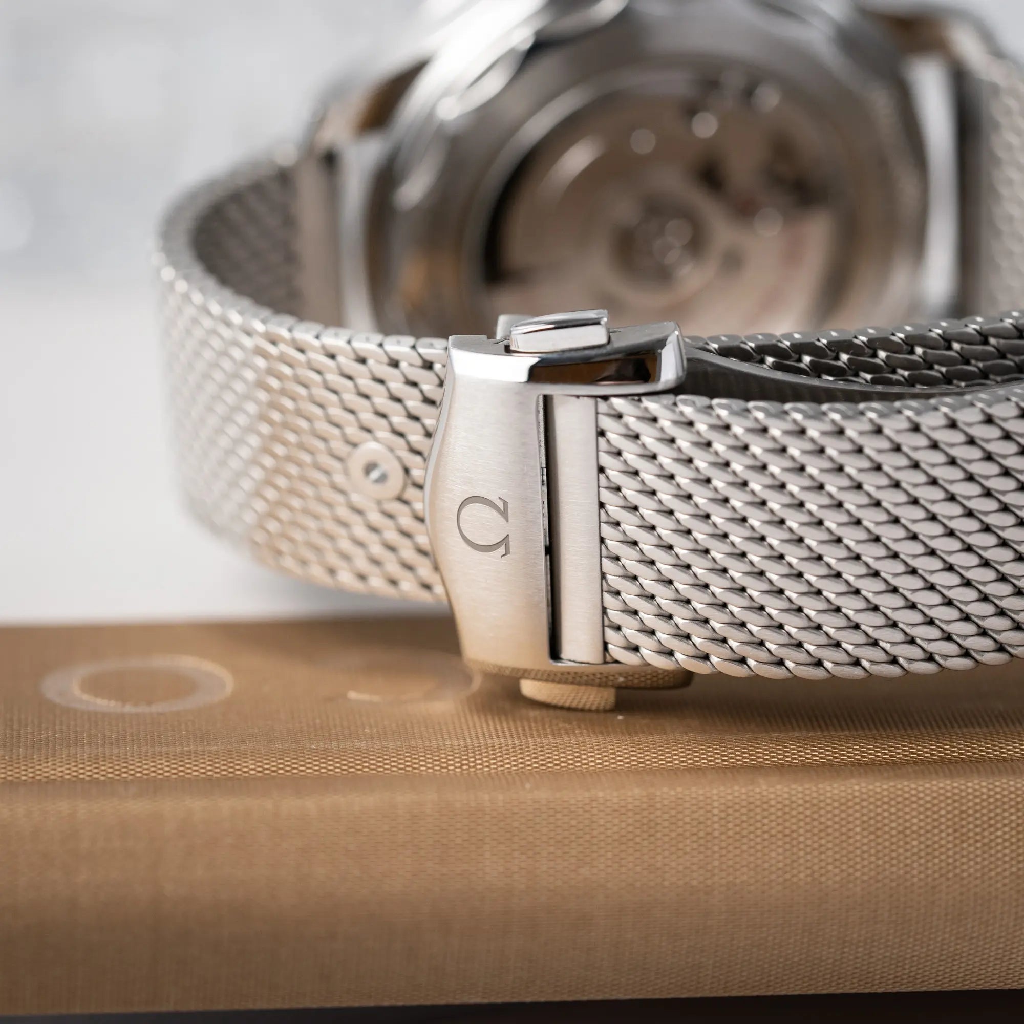 Detailaufnahme der Omega-Faltschliesse am Milaneseband der Omega Seamaster 300M Diver 210.30.42.20.01.010 mit dems schwarzen Zifferblatt im Wellen-Design 