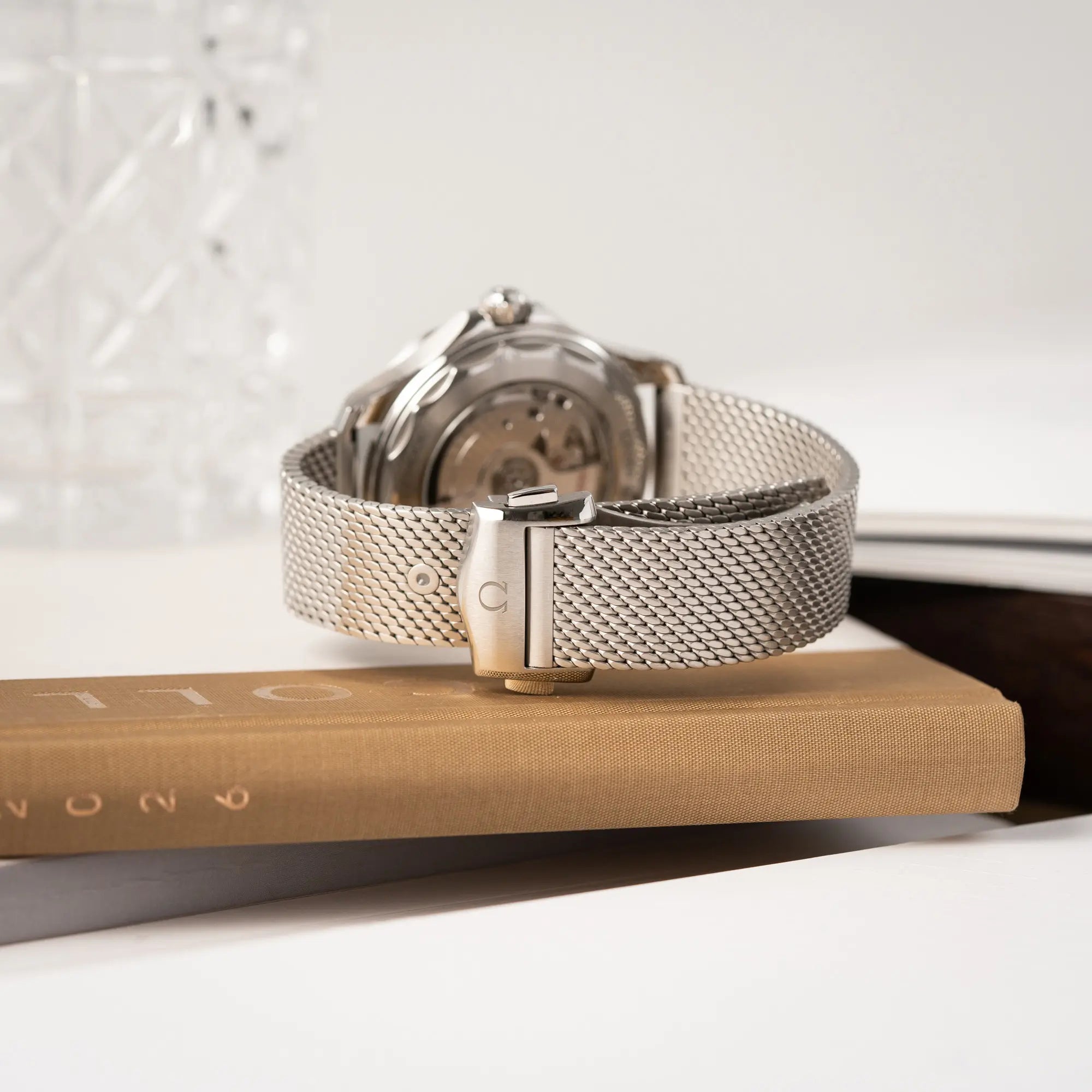 Produktfotografie der Omega Seamaster 300M Diver 210.30.42.20.01.010 mit dems schwarzen Zifferblatt im Wellen-Design zeigt das Milanese-Edelstahl-Armband 