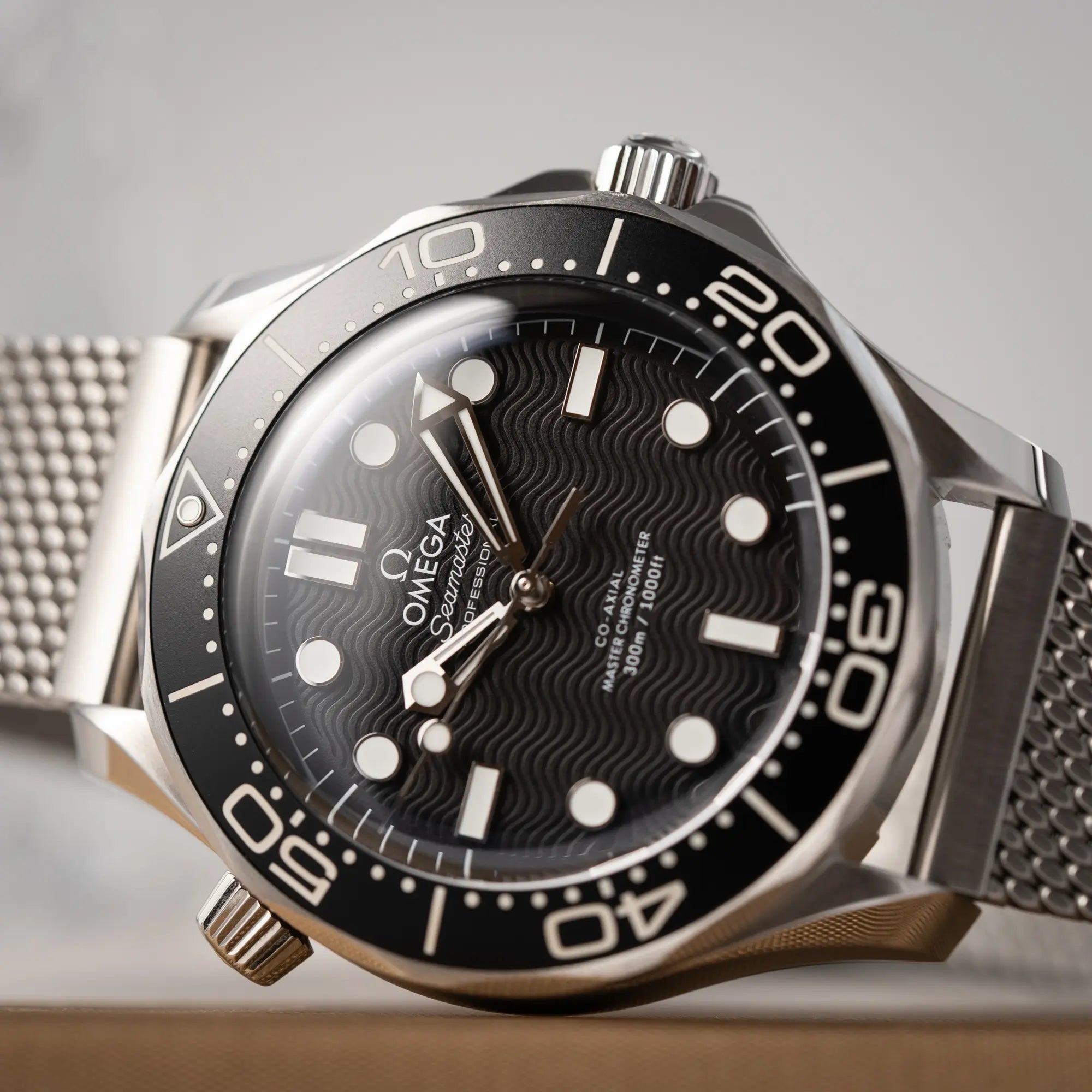 Detailaufnahme des Uhrenkopfes der Omega Seamaster 300M Diver 210.30.42.20.01.010 mit dems schwarzen Zifferblatt im Wellen-Design am Milanese-Edelstahl-Armband