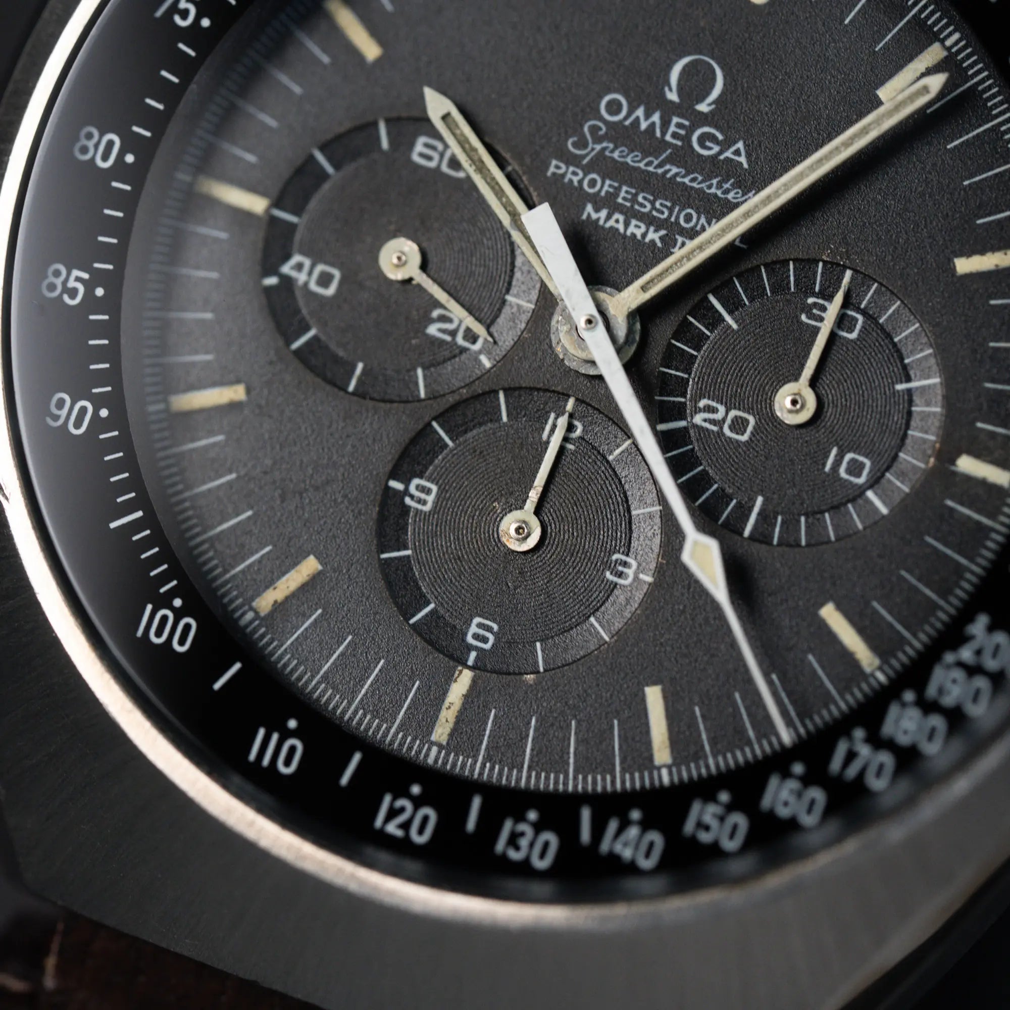 Makroaufnahme des schwarz/ anthraziten Zifferblatts der Omega Speedmaster Moonwatch Mark 2 an einem braunen Lederarmband