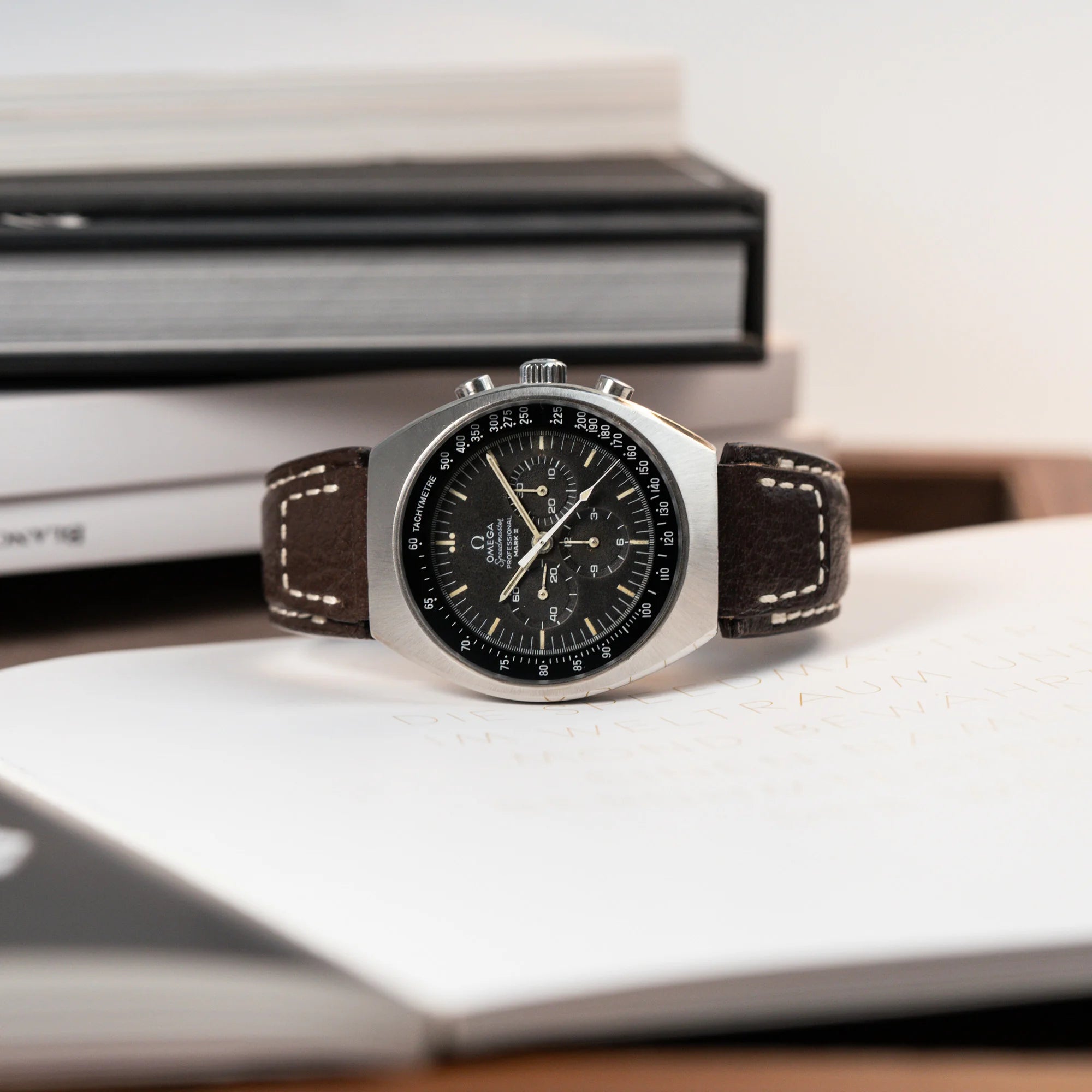 Produktfotografie der liegenden Omega Speedmaster Moonwatch Mark 2 an einem braunen Lederarmband