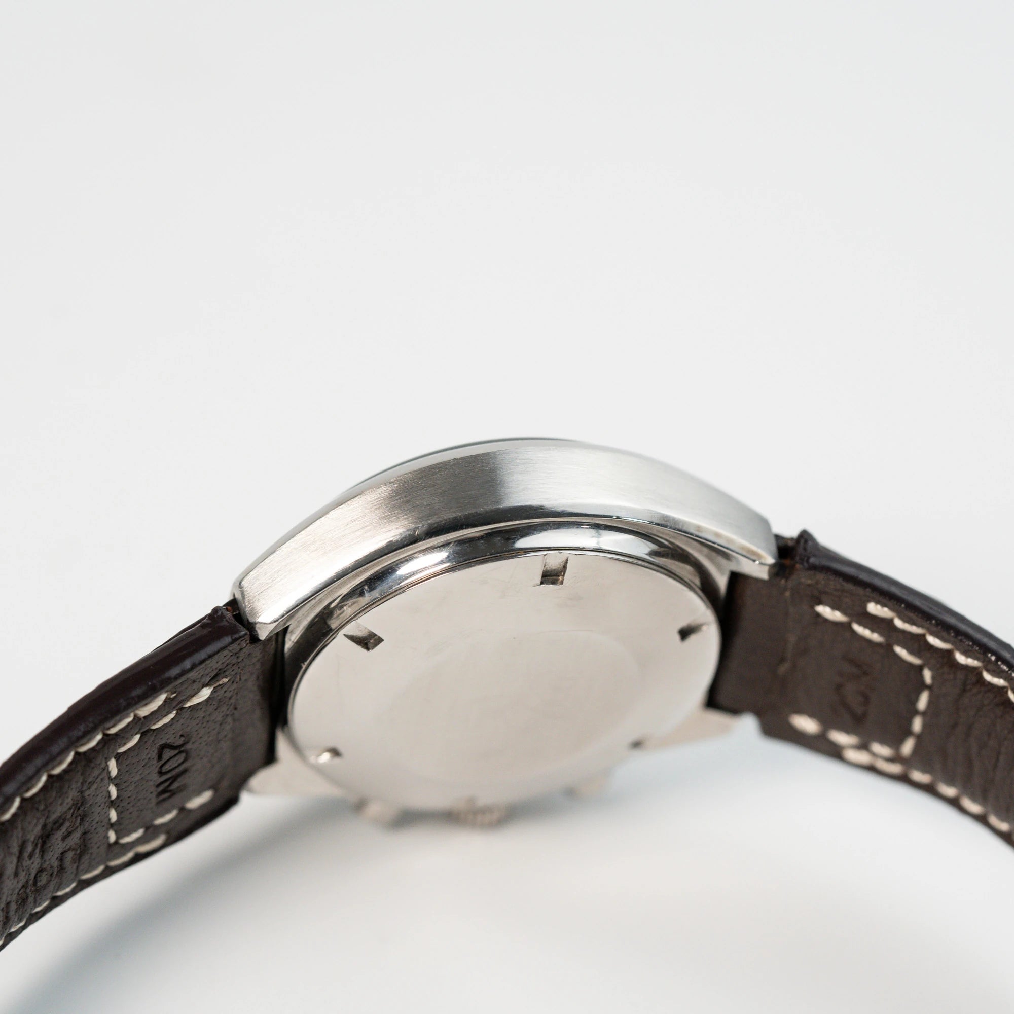 Seitliches Gehäuse und Gehäuseboden der Omega Speedmaster Moonwatch Mark 2 an einem braunen Lederarmband
