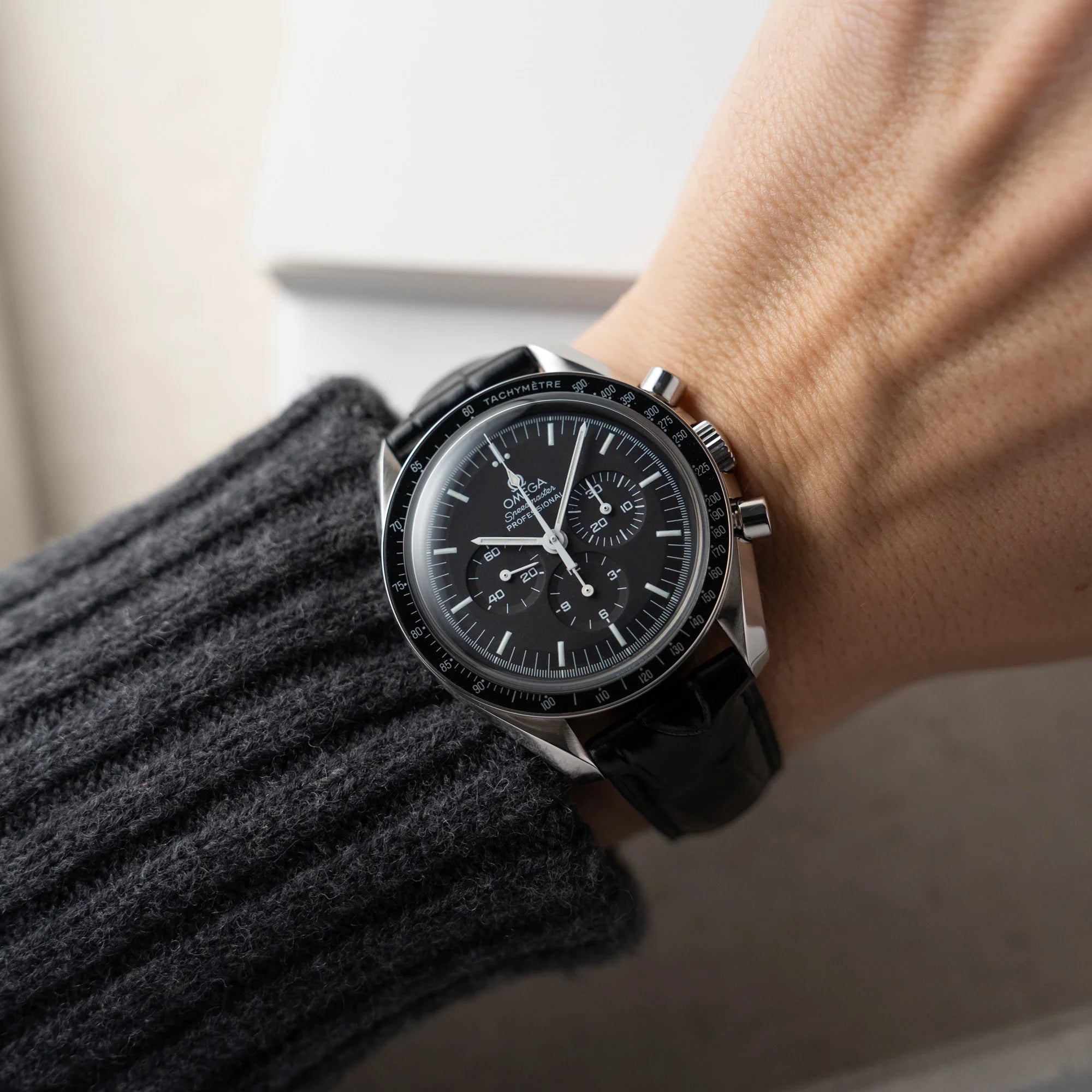 Mann trägt die Omega Speedmaster Moonwatch Professional am schwarzen Lederband an seinem Handgelenk