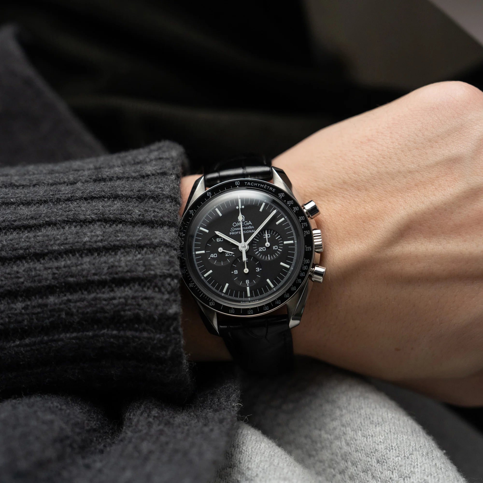 Mann trägt die Omega Speedmaster Moonwatch Professional am schwarzen Lederband an seinem Handgelenk