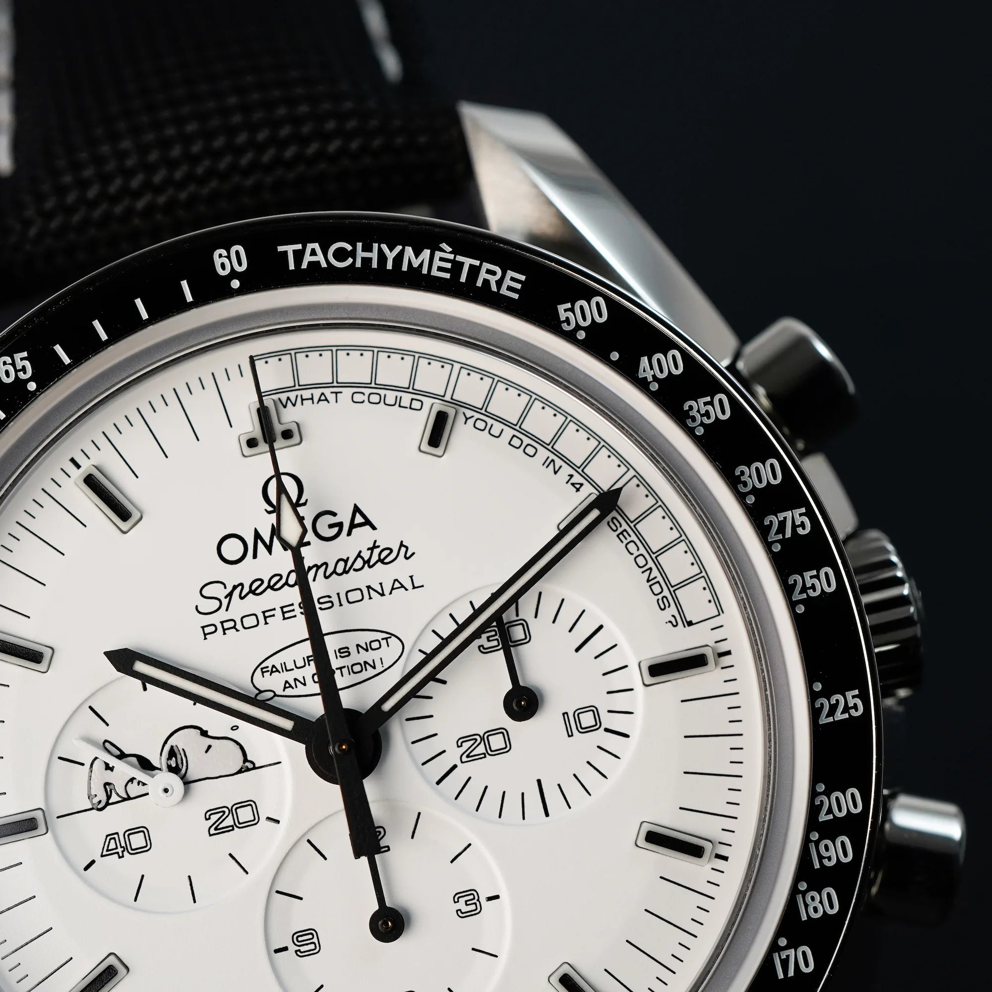 Makroaufnahme des weißen Zifferblatts und der Tachymetre-Skala der limitierten Omega Speedmaster Moonwatch Silver Snoopy mit dem weißen Zifferblatt