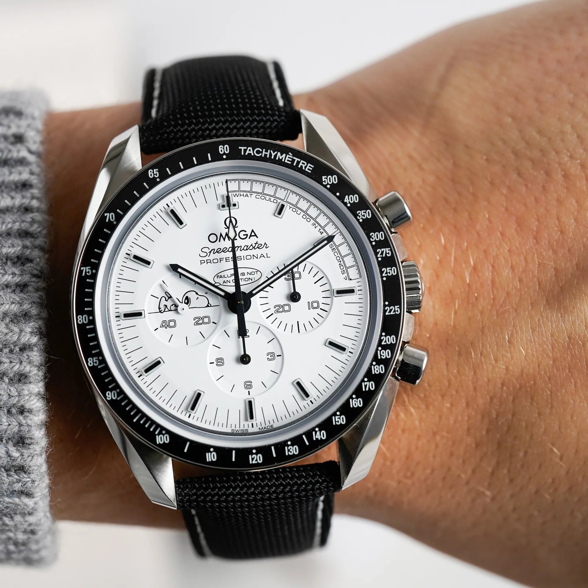 Wristshot der limitierten Omega Speedmaster Moonwatch Silver Snoopy mit dem weißen Zifferblatt