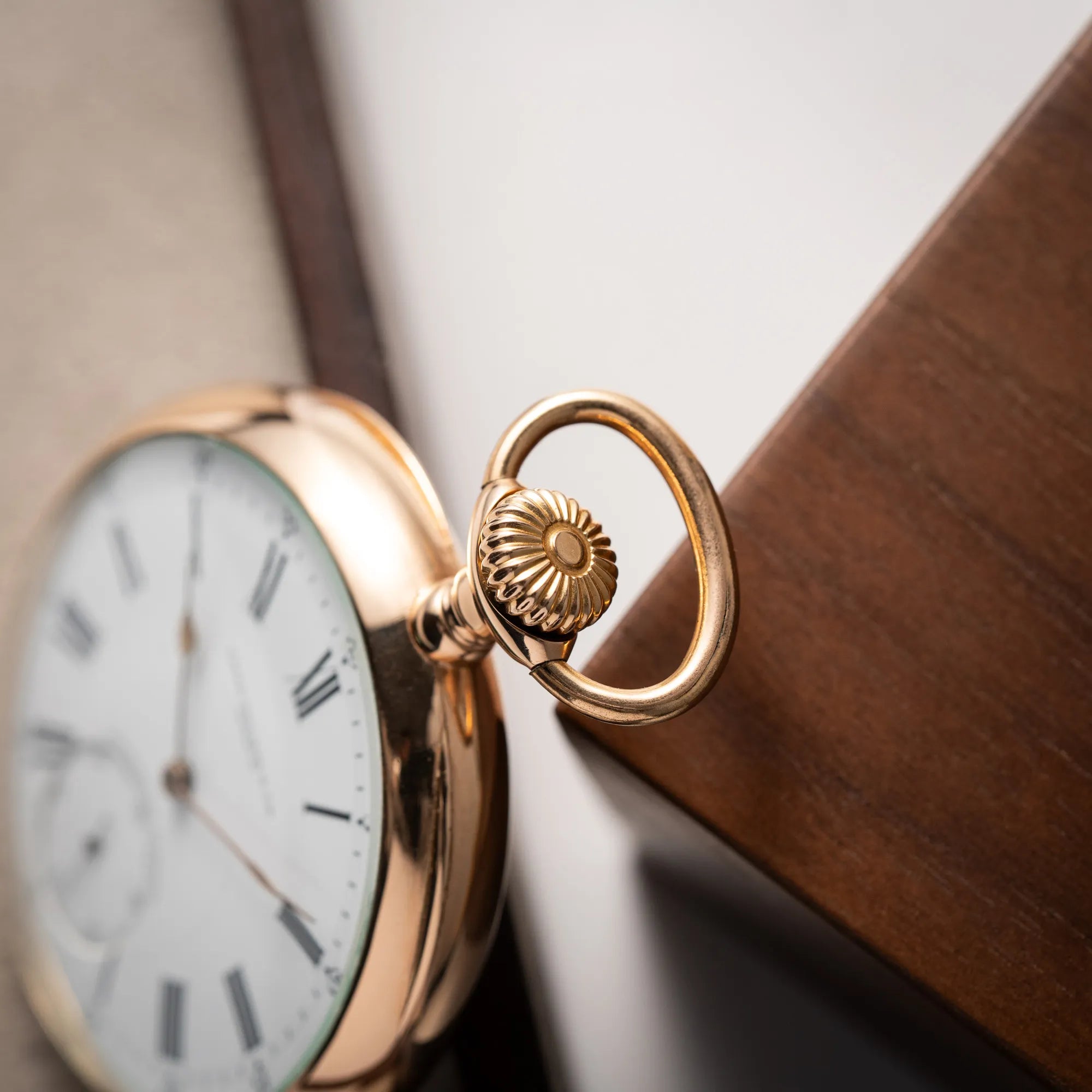 Produktfotografie zeigt die Aufzugskrone der Patek Philippe Gondolo Taschenuhr aus 18k Gelbgold mit weißem Zifferblatt und römischen Indizes