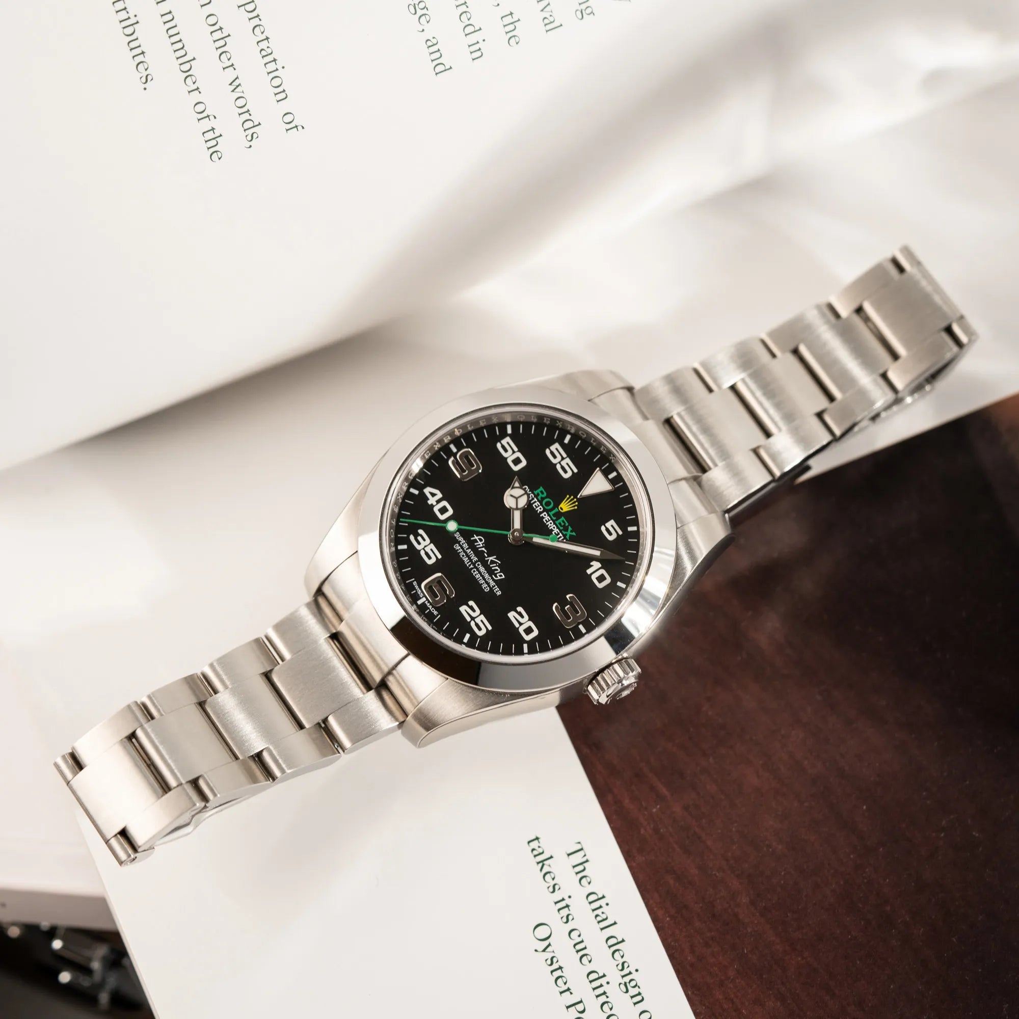 Produktfotografie der flach liegenden Rolex Oyster Perpetual Air King 116900 mit 40mm Gehäuse und dem klassischen schwarzen Zifferblatt mit grünem Sekundenzeiger