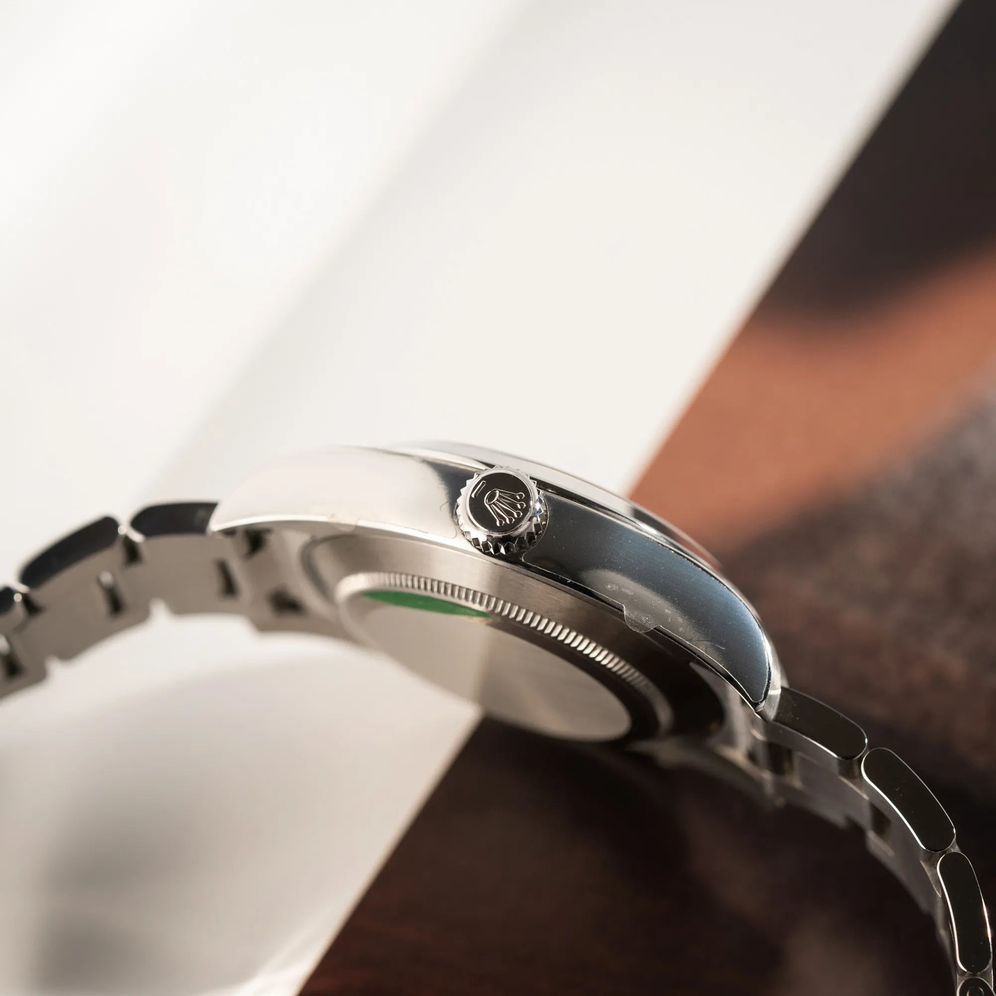 Seitliche Gehäuseflanke mit Sticker und Aufzugskrone der Rolex Oyster Perpetual Air King 116900 mit 40mm Gehäuse und dem klassischen schwarzen Zifferblatt mit grünem Sekundenzeiger