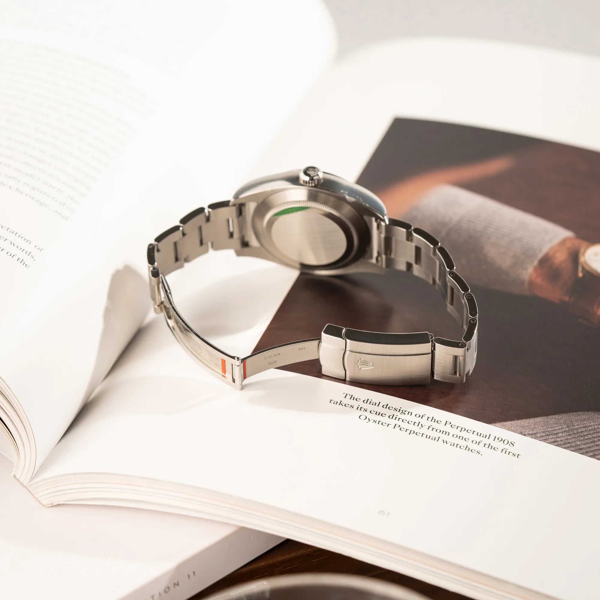 Produktfotografie der Rolex Oyster Perpetual Air King 116900 mit 40mm Gehäuse und dem klassischen schwarzen Zifferblatt mit grünem Sekundenzeiger zeigt die verklebten Sticker