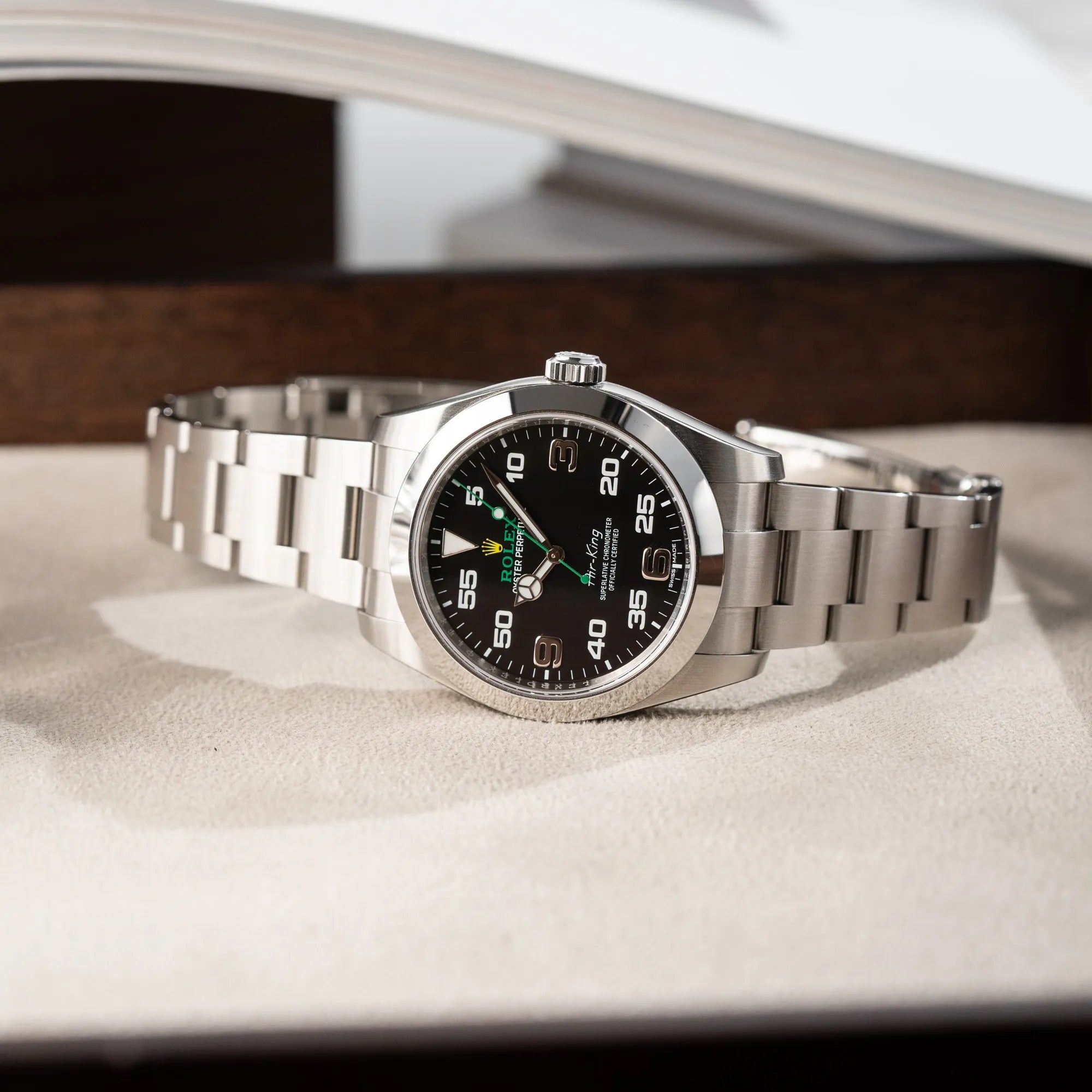 Produktfotografie der Rolex Oyster Perpetual Air King 116900 mit 40mm Gehäuse und dem klassischen schwarzen Zifferblatt mit grünem Sekundenzeiger auf einem Juwelierstablet