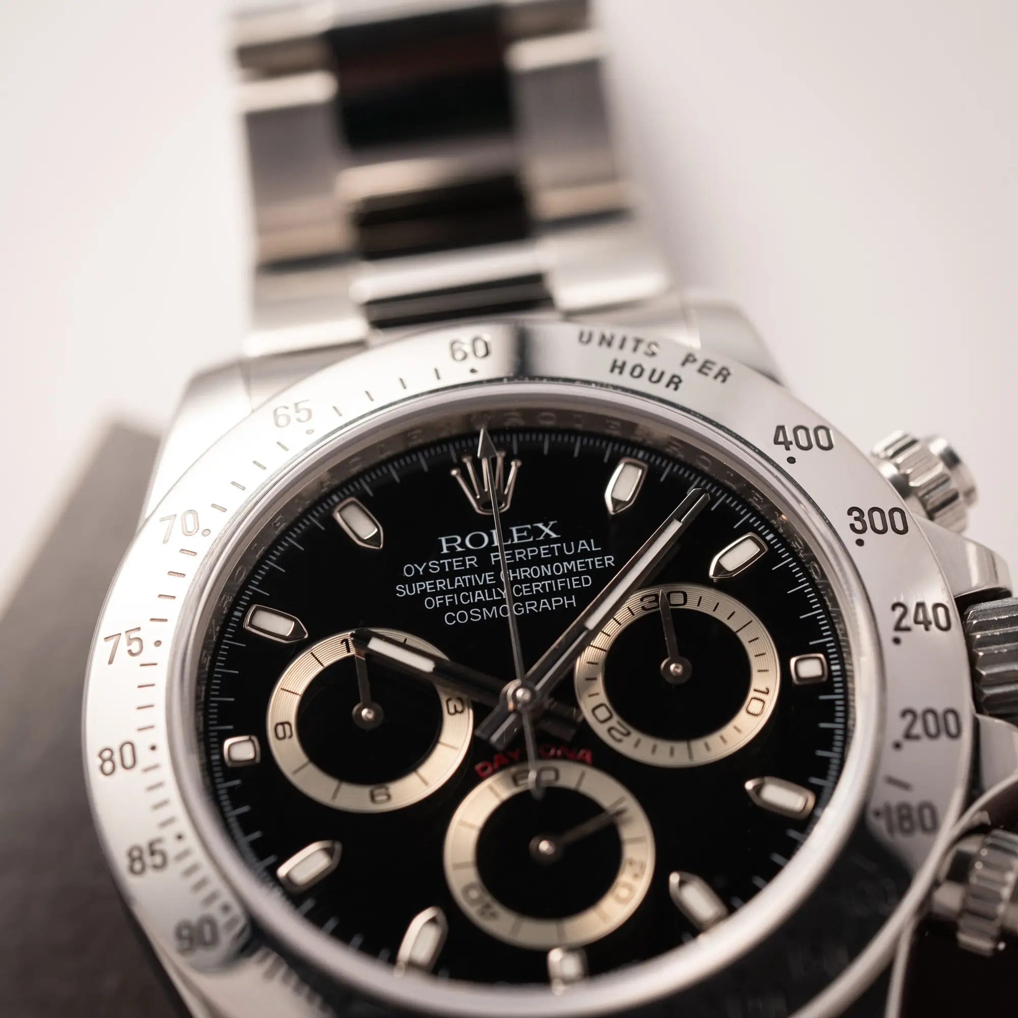 Detailaufnahme des Uhrengehäuses von der Rolex Cosmograph Daytona 116520 mit schwarzem Zifferblatt und der klassischen Edelstahl-Lünette vor Umstellung auf die Keramik-Lünette