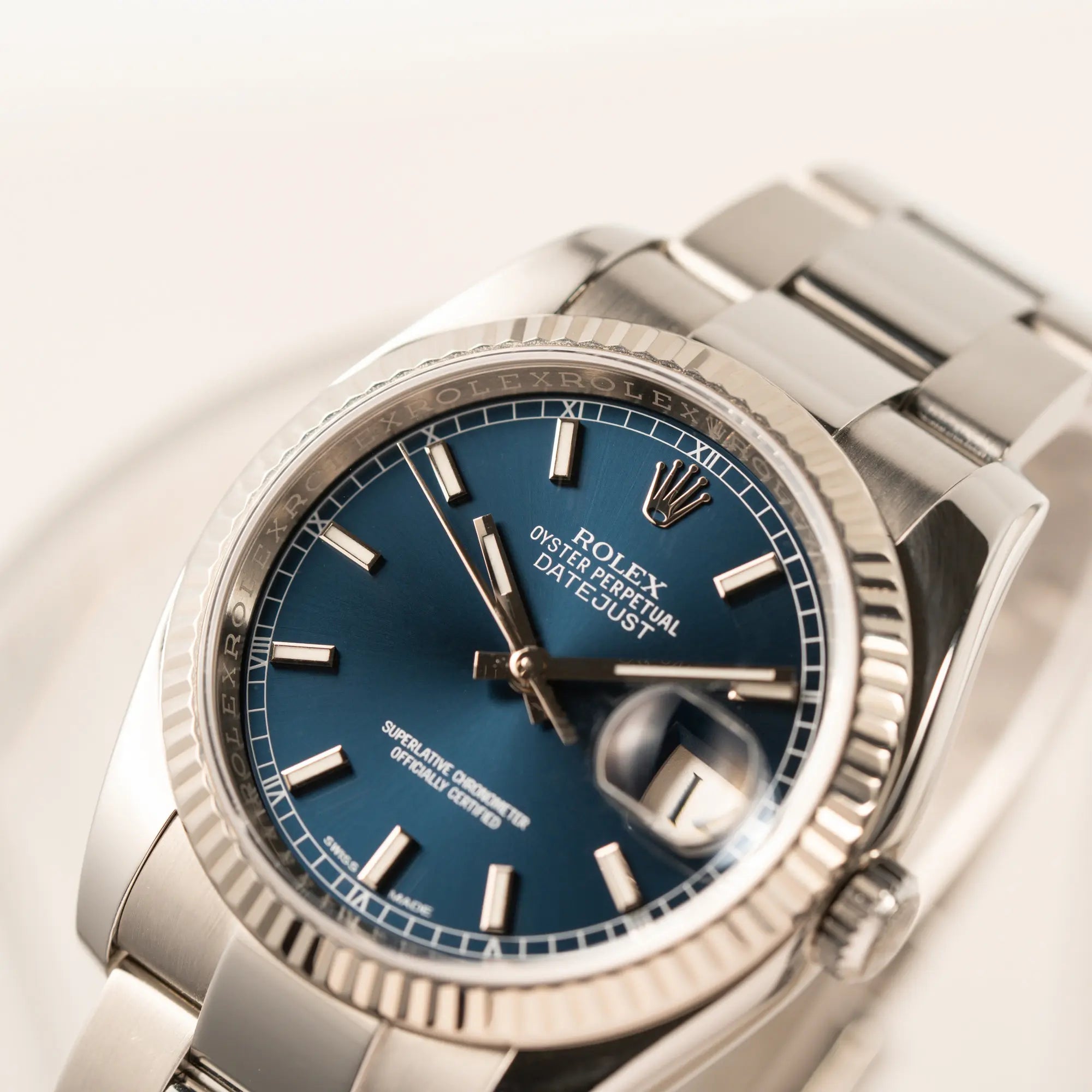 Nahaufnahme der Rolex Datejust 36 der Referenz 116234 mit geriffelter Lünette und blauem Sonnenschliff-Zifferblatt