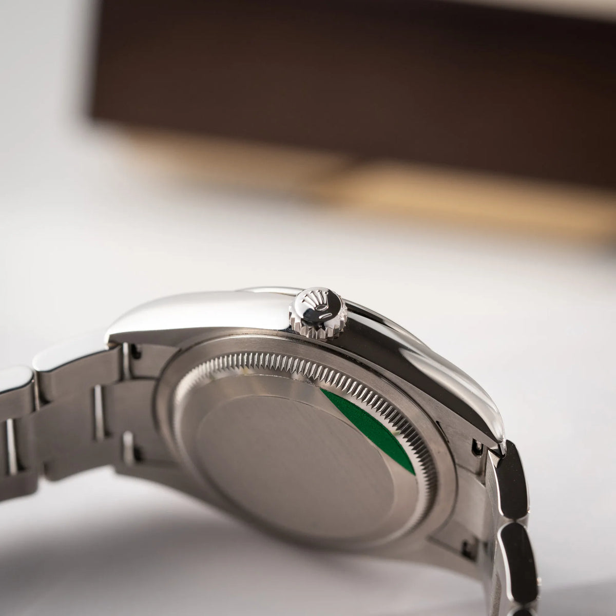 Produktfotografie der mit Stickern teil-verklebte Rolex Datejust 36 der Referenz 126200 mit glatter Lünette am Oyster-Stahlband mit dem Mint-Green-Zifferblatt  zeugt die Aufzugskrone und den verklebten Gehäuseboden