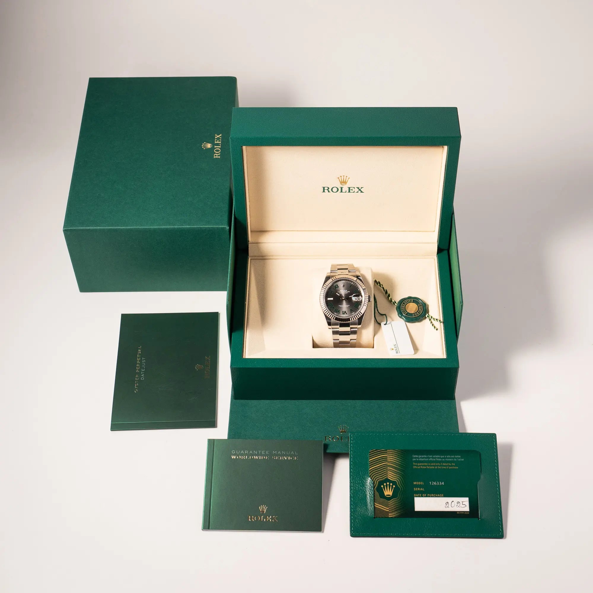 Lieferumfang zugehörig zu der Rolex Datejust 41 der Referenz 126334 mit geriffelter Weißgold-Lünette und Oyster-Stahlband mit dem grauen Wimbledon-Zifferblatt mit schwarz-grünen Indizes, bestehend aus Box mit Umkarton, Hangtags, allen Booklets und originaler Garantiekarte