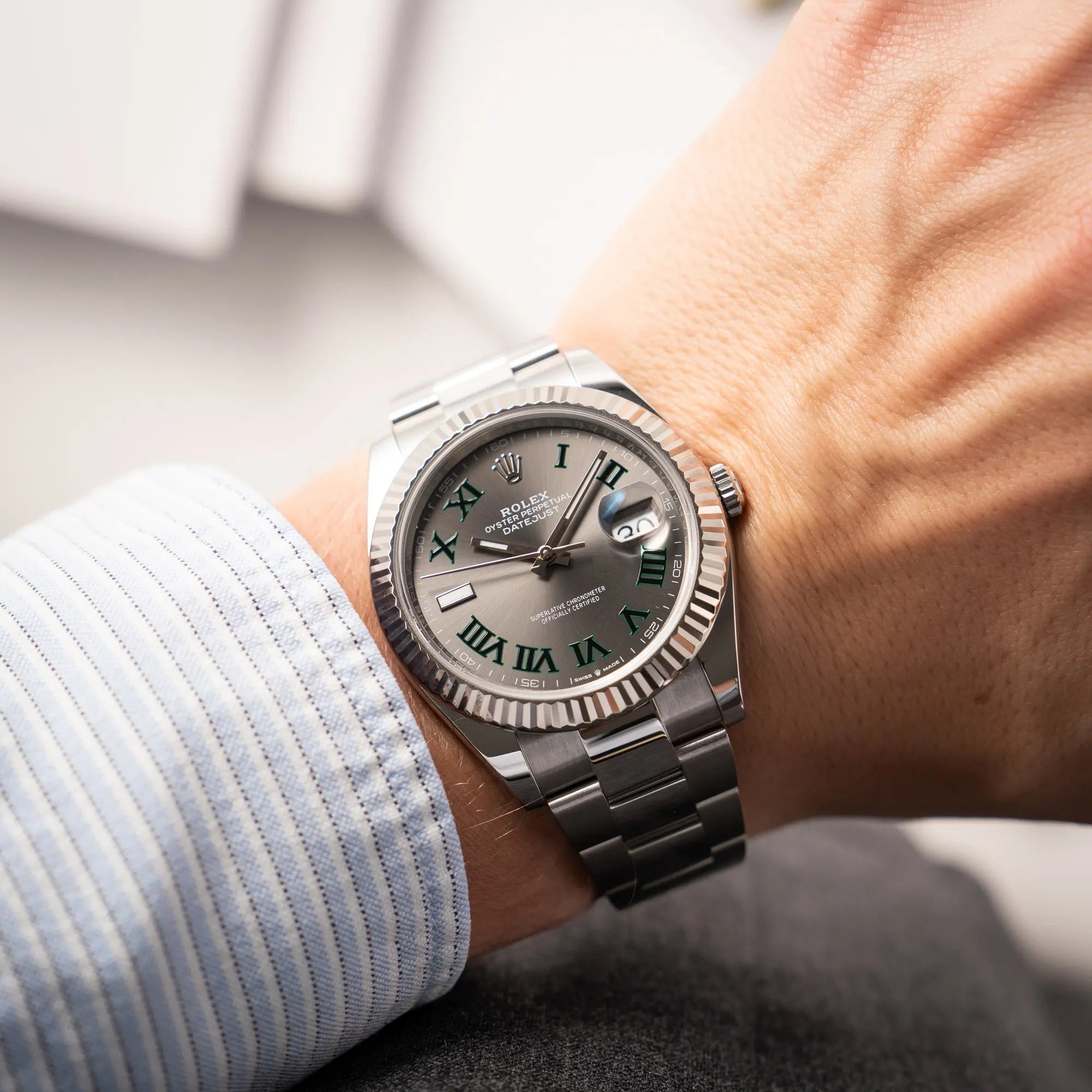 Wristshot mit der Rolex Datejust 41 der Referenz 126334 mit geriffelter Weißgold-Lünette und Oyster-Stahlband mit dem grauen Wimbledon-Zifferblatt mit schwarz-grünen Indizes
