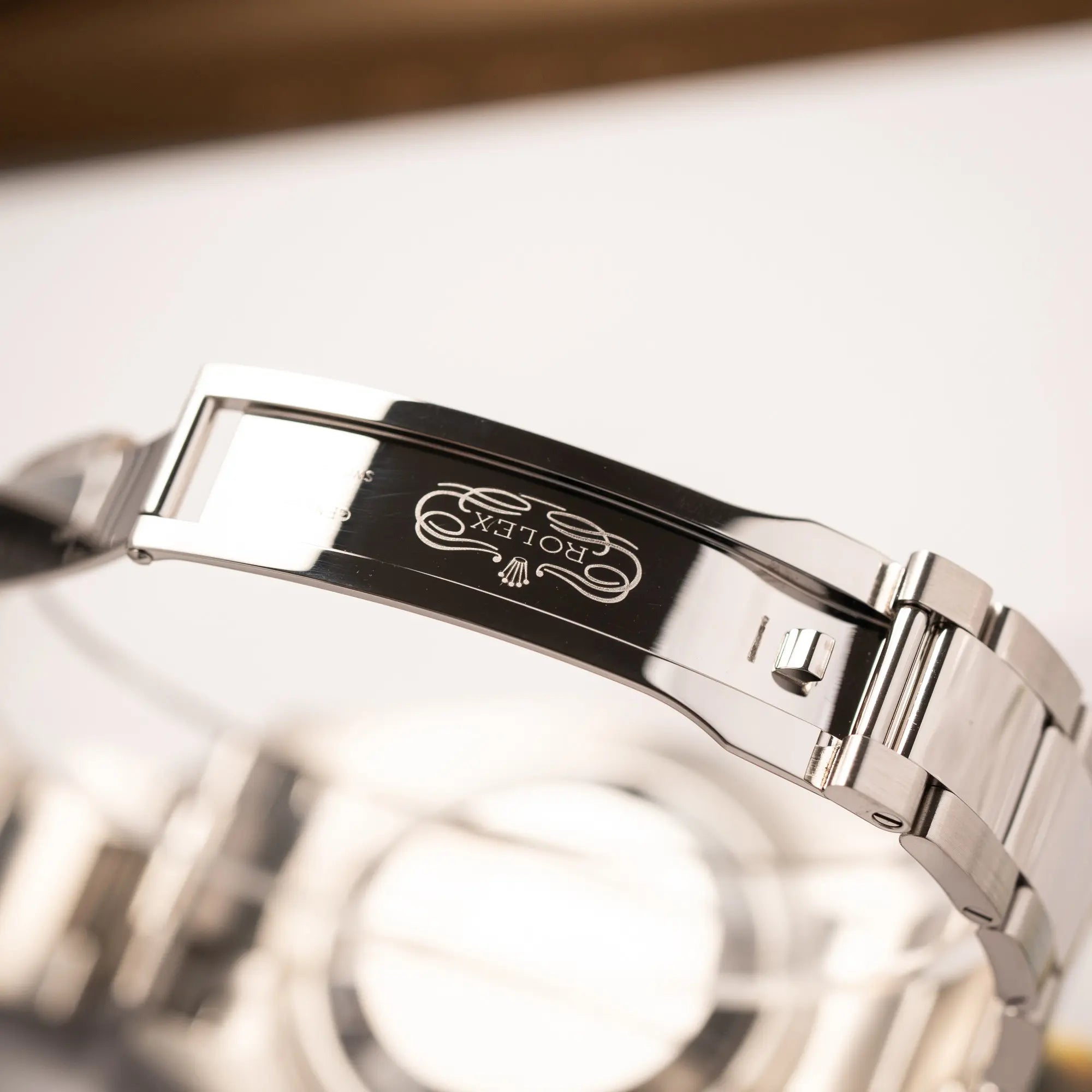 Klassisches Rolex-Logo im Inneren der Oyster-Faltschliesse der Rolex Datejust 41 der Referenz 126334 mit geriffelter Weißgold-Lünette und Oyster-Stahlband mit dem grauen Wimbledon-Zifferblatt mit schwarz-grünen Indizes