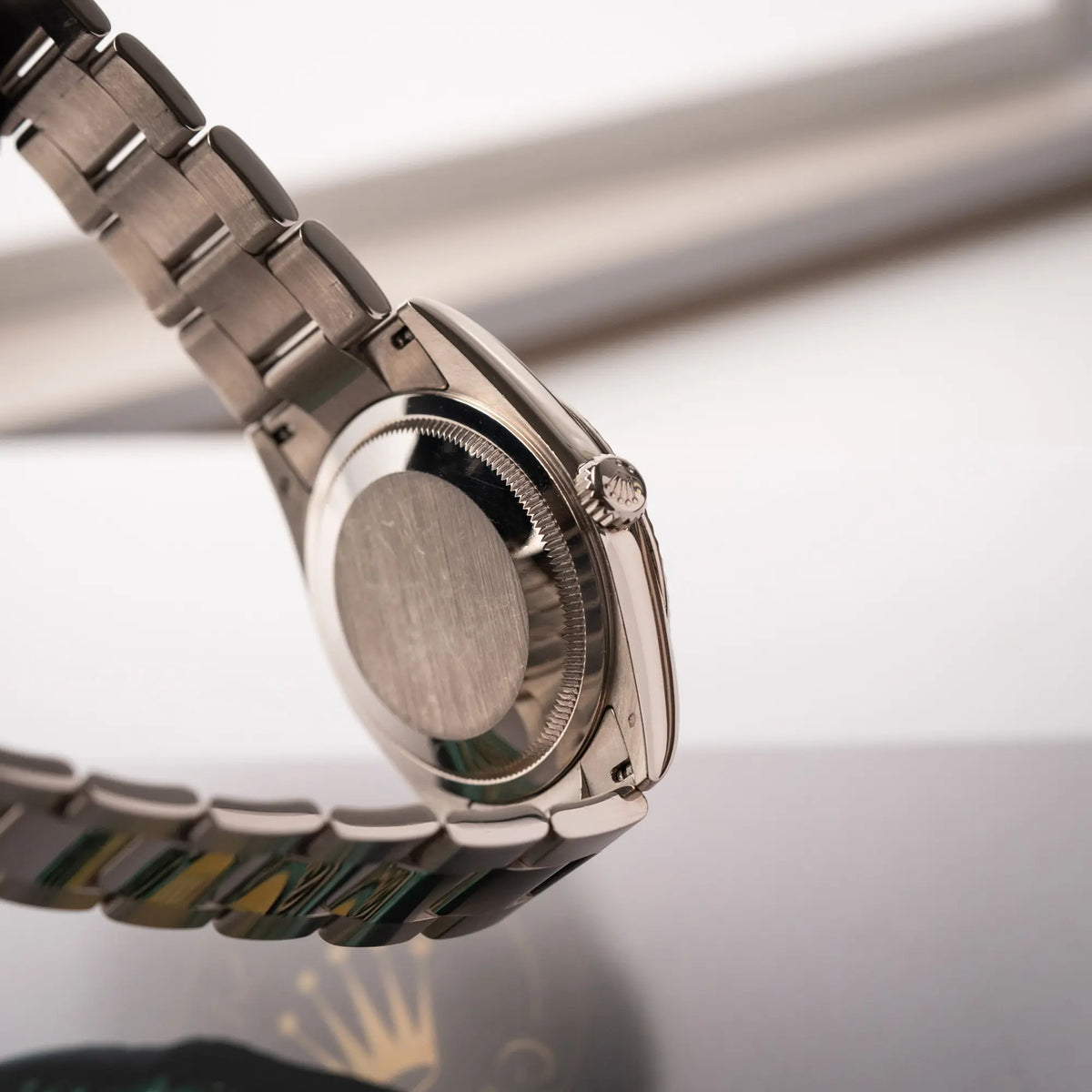 Produktfotografie der Rolex Day-Date 36 Armbanduhr in Weißgold der Referenz 118239 mit weißem Zifferblatt mit römischen Indizes am Oyster-Weißgold-Armband zeigt den Gehäuseboden und die Aufzugskrone
