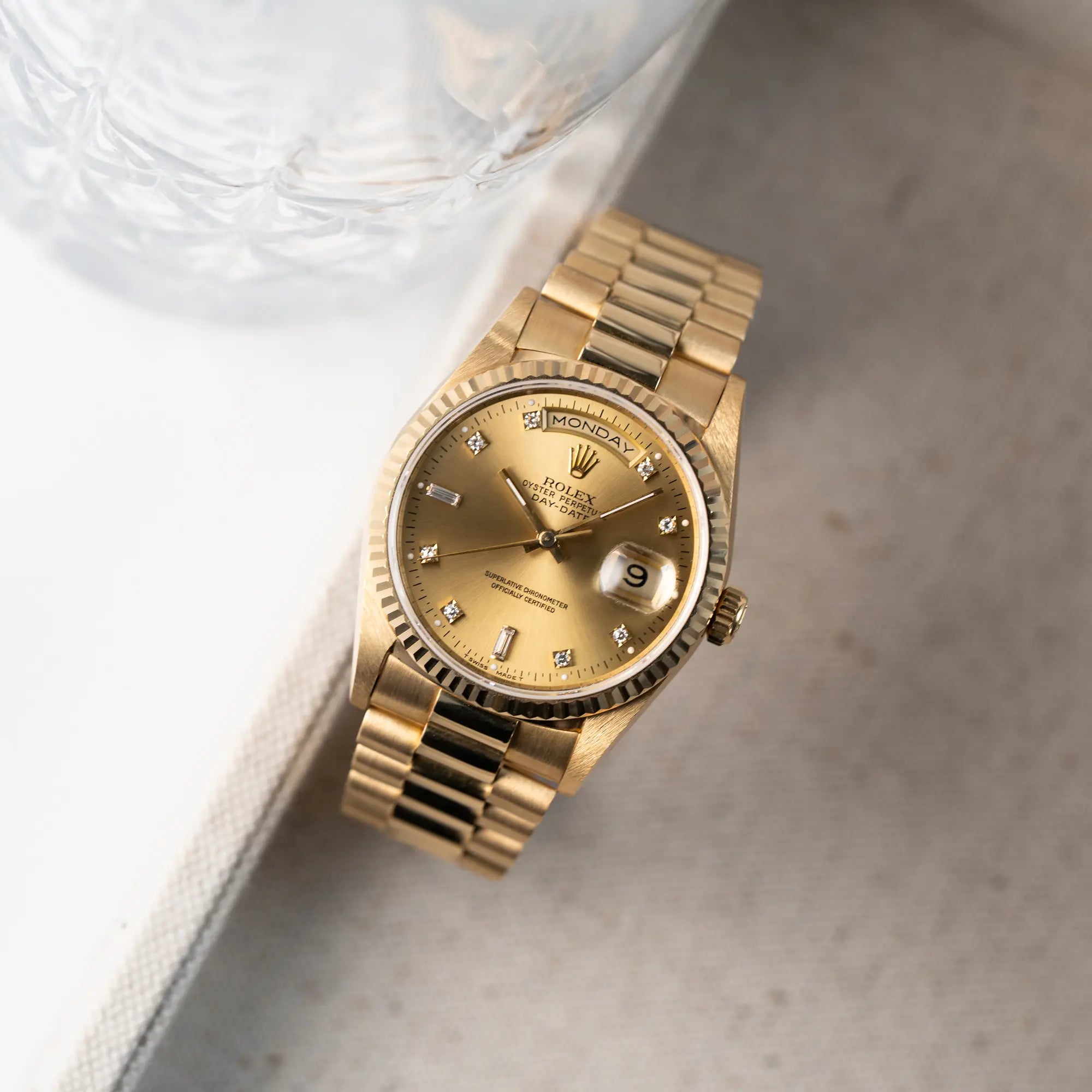 Produktfotografie der Rolex Day-Date 18238 in Gelbgold mit goldenem Zifferblatt und Diamant-Indizes am President-Armband (aus der Vodelperspektive)