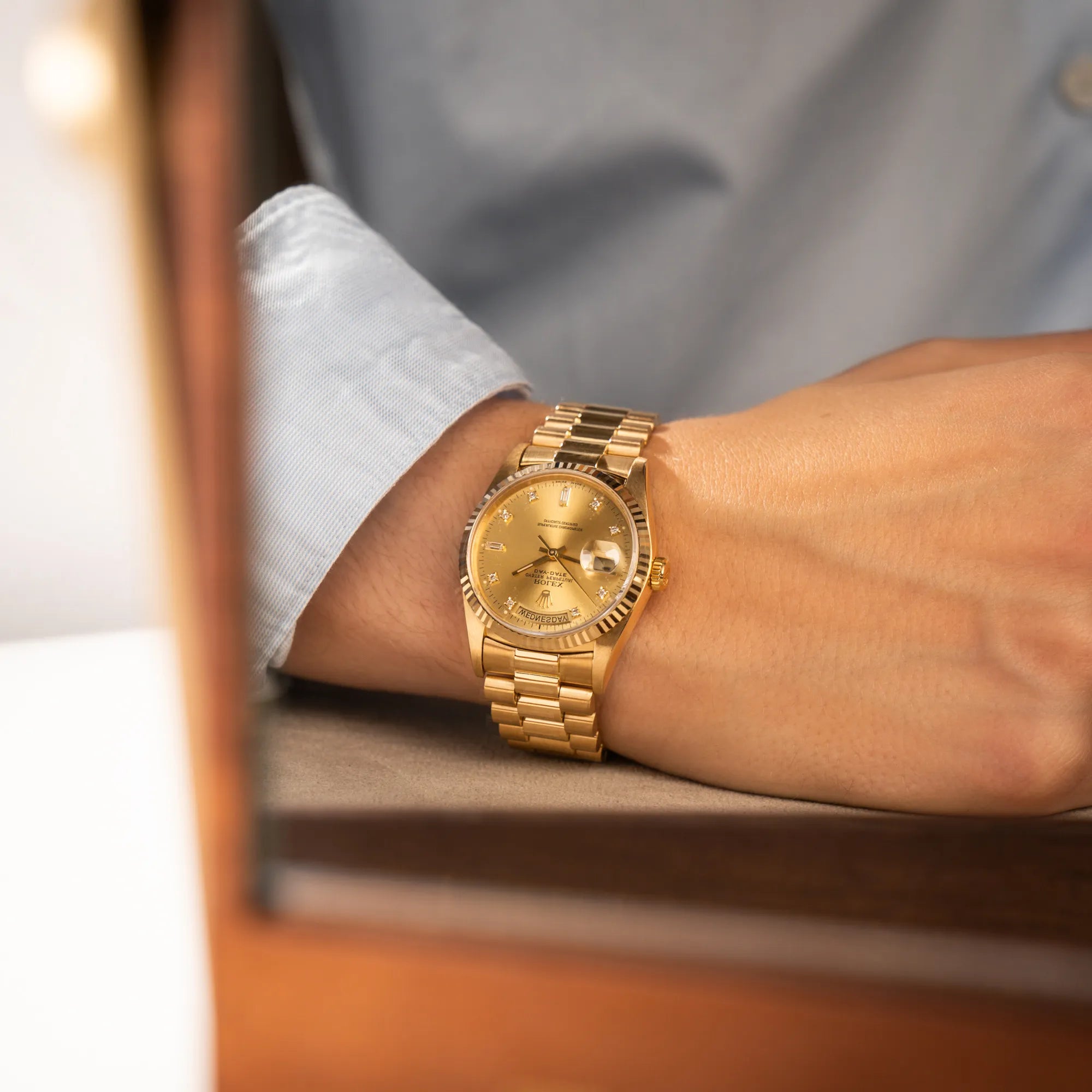 Mann hat die Rolex Day-Date 36 in Gelbgold mit der Referenz 18238 und Champagne-Diamant-Zifferblatt am Arm