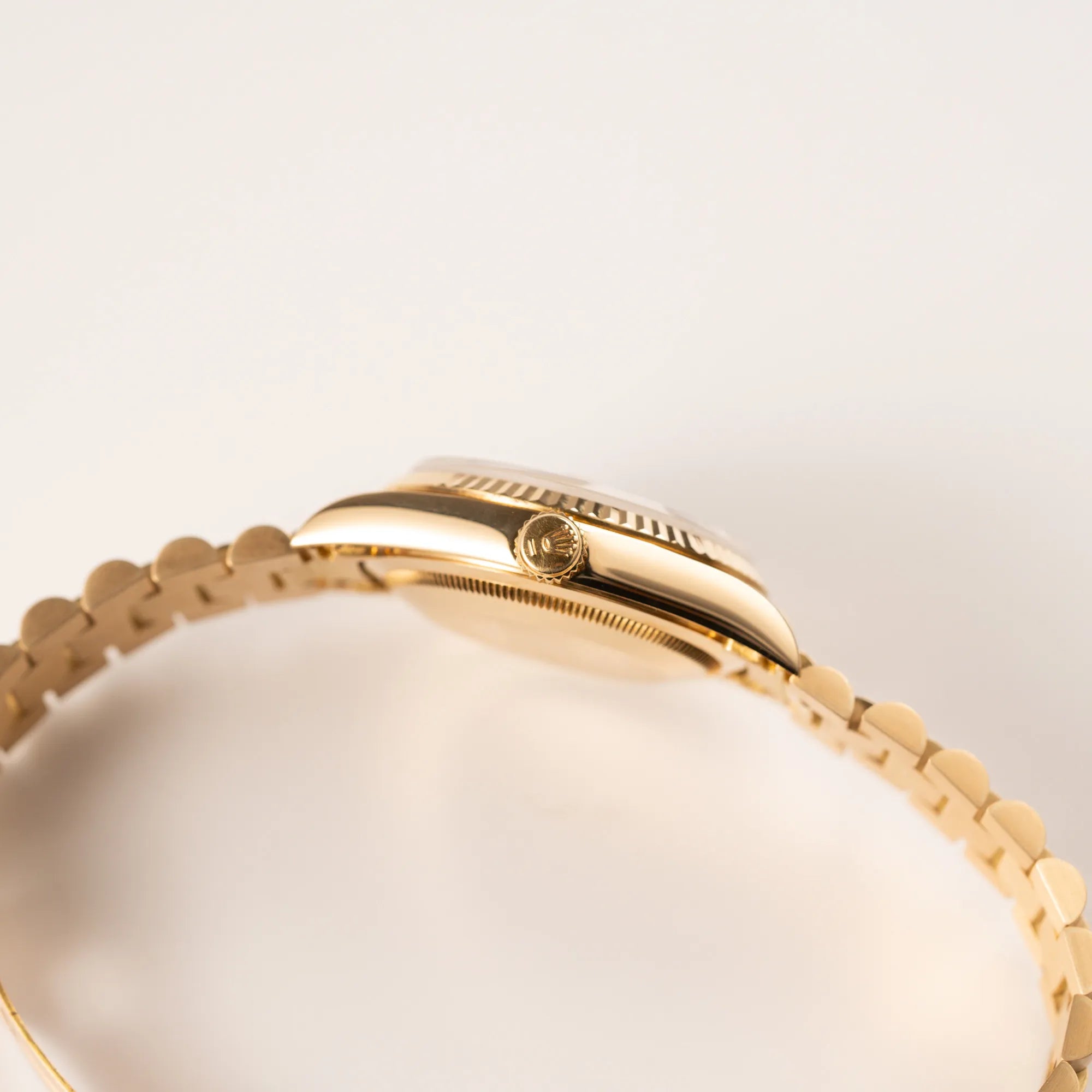 Seitliches Gehäuse der Rolex Day-Date 36 in Gelbgold mit der Referenz 18238 und Champagne-Diamant-Zifferblatt mit Blick auf die Aufzugskrone