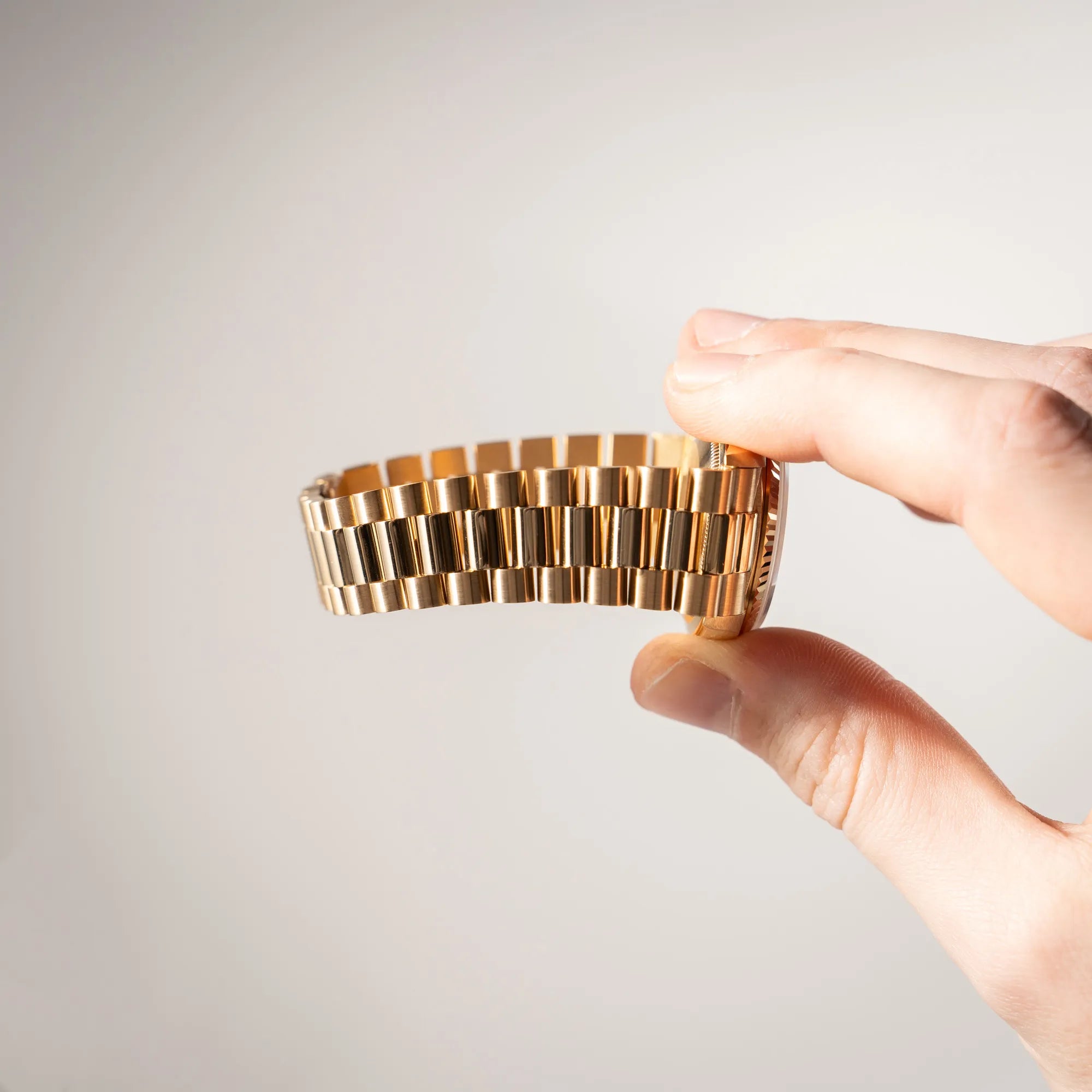 Mann hält die Rolex Day-Date 36 in Gelbgold der Referenz 18238 aus 1991 mit Champagner-Diamant-Zifferblatt und englischsprachiger Tagesanzeige und zeigt den kaum vorhandenen Stretch des President-Armbands