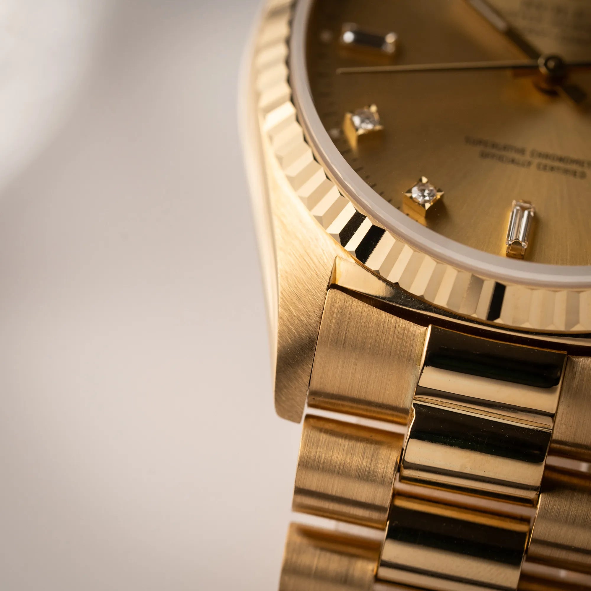 Detailaufnahme des linken unteren Bandanstoßes der Rolex Day-Date 36 in Gelbgold der Referenz 18238 aus 1991 mit Champagner-Diamant-Zifferblatt und englischsprachiger Tagesanzeige