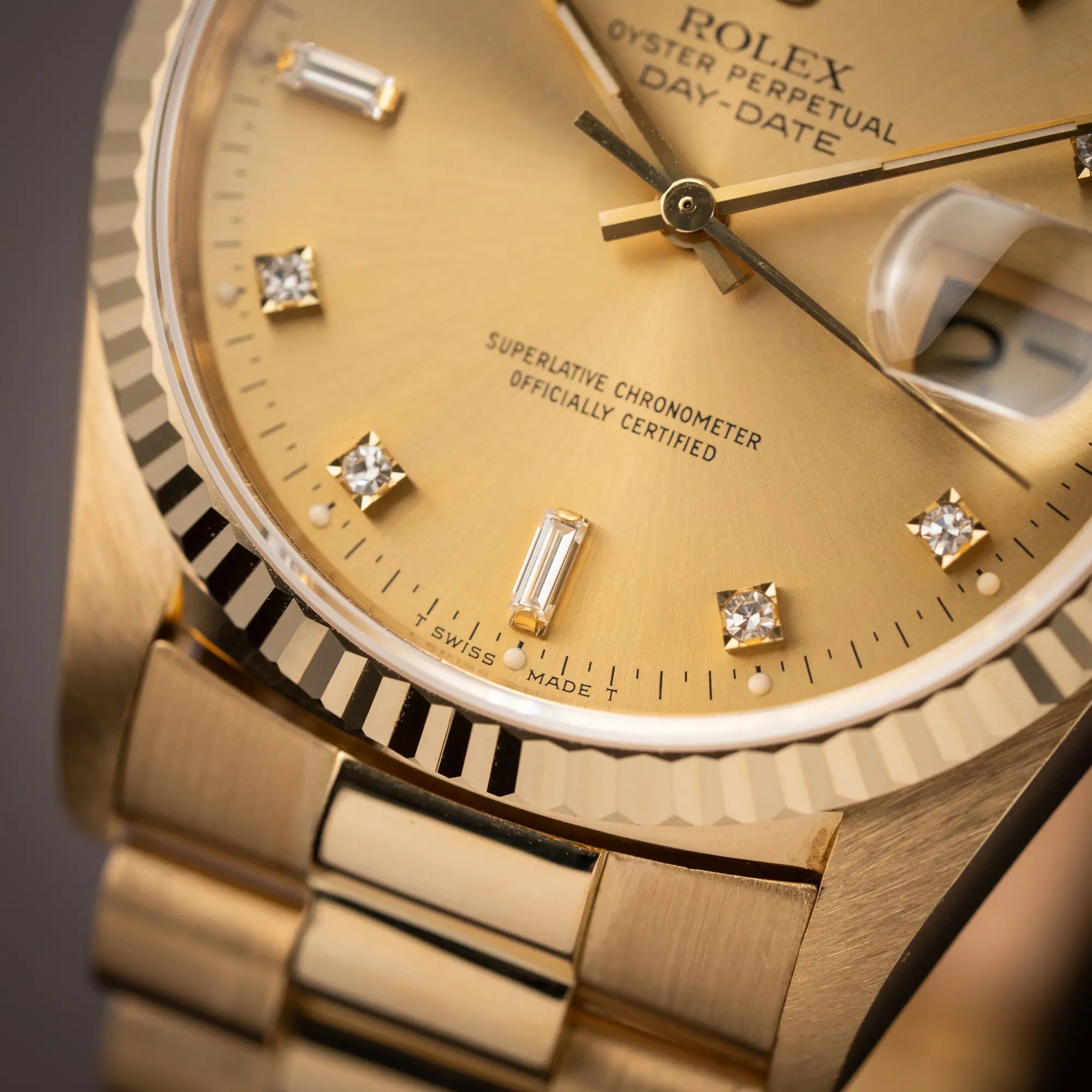 Detailaufnahme des "T Swiss Made T" Schriftzugs auf 6 Uhr der Rolex Day-Date 36 in Gelbgold der Referenz 18238 aus 1991 mit Champagner-Diamant-Zifferblatt und englischsprachiger Tagesanzeige