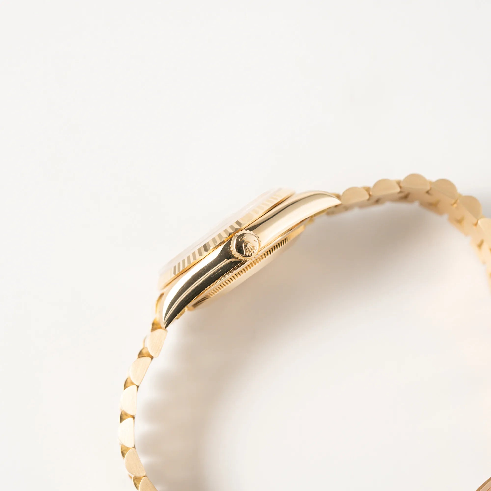 Seitliche Gehäuseflanke mit Blick auf die Aufzugskrone der Rolex Day-Date 36 in Gelbgold der Referenz 18238 aus 1991 mit Champagner-Diamant-Zifferblatt und englischsprachiger Tagesanzeige