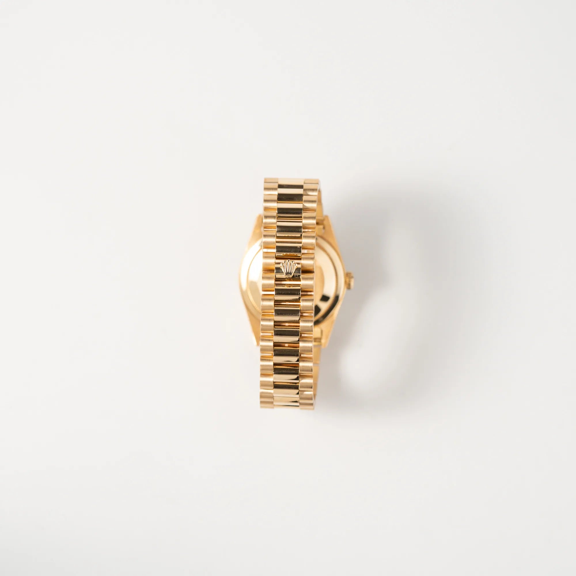 Blick auf das President-Armband mit scharfkantiger Rolex-Krone auf der Schliesse von der Rolex Day-Date 36 in Gelbgold der Referenz 18238 aus 1991 mit Champagner-Diamant-Zifferblatt und englischsprachiger Tagesanzeige