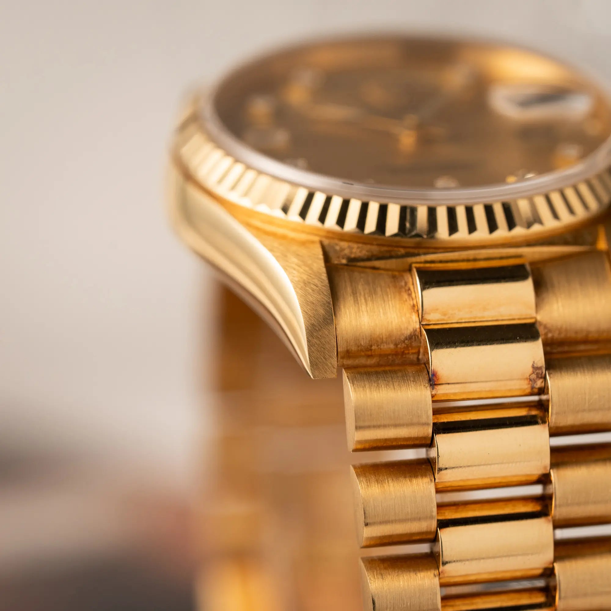 Produktfotografie zeigt die Patina auf dem Rolex President Armband auf dem Gold von der Rolex Day-Date 36 der Referenz 18238 mit champagnerfarbenem Diamant-Zifferblatt