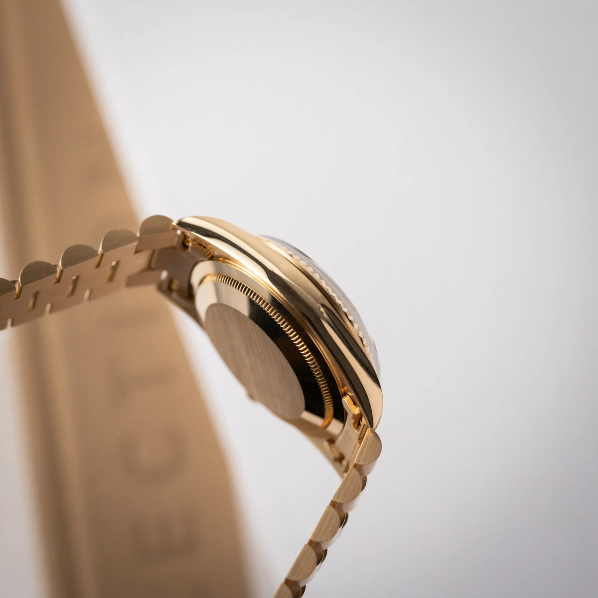 Seitliche Gehäuseflanke der Rolex Day-Date 36 der Referenz 18238 in Gelbgold mit schwarzen Diamond-Dial am President-Armband