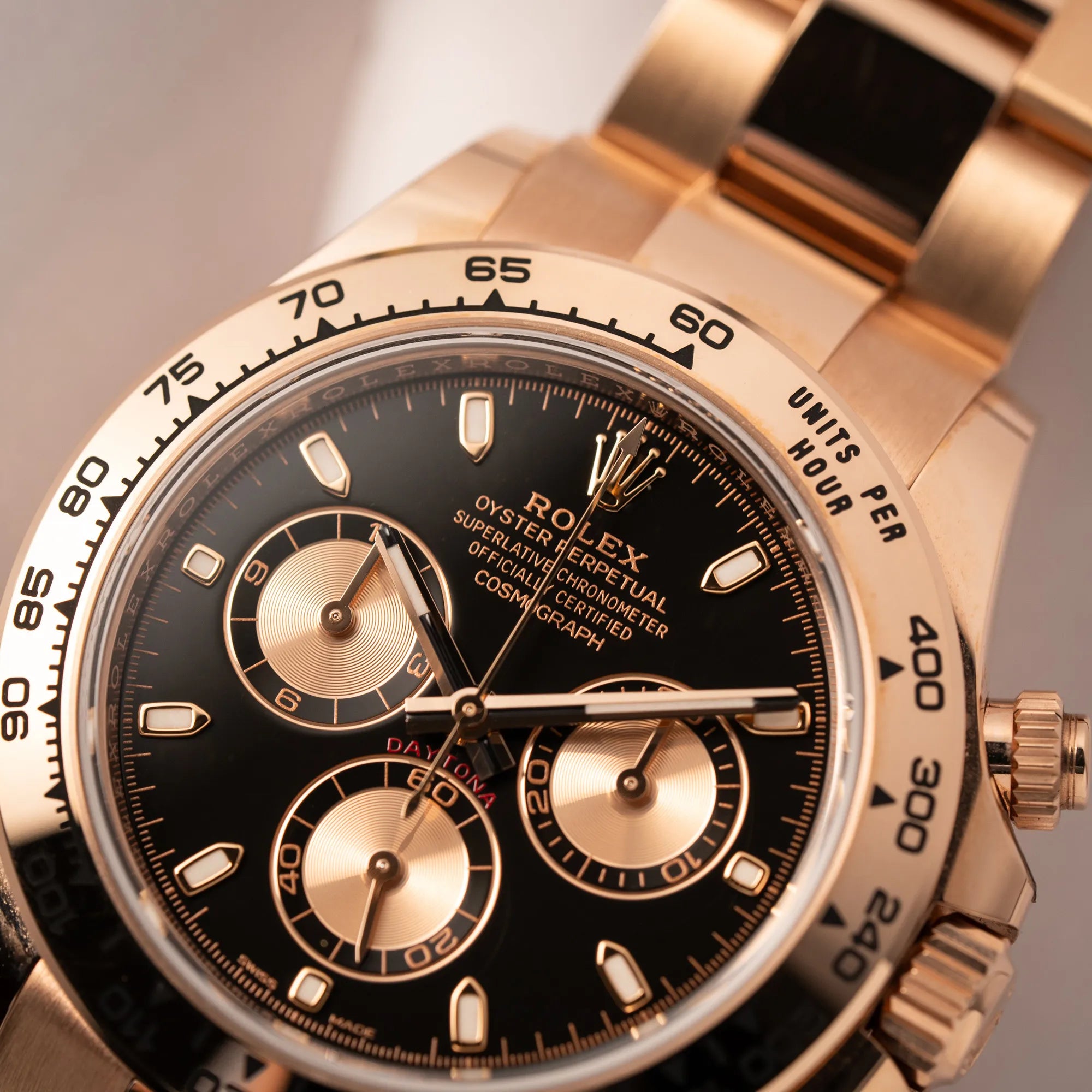 Detailaufnahme der Rolex Daytona Chronograph-Armbanduhr der Referenz 116505 in Everrose-Roségold mit schwarzem Zifferblatt am Oyster-Roségold-Band zeigt den Zeigersatz