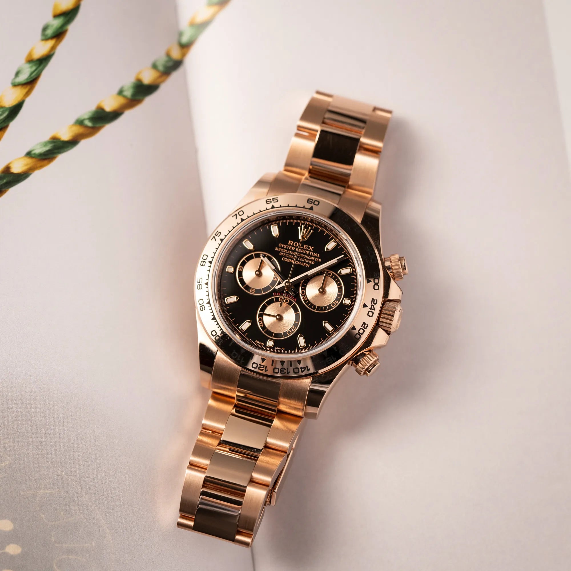 Produktfotografie der Rolex Daytona Chronograph-Armbanduhr der Referenz 116505 in Everrose-Roségold mit schwarzem Zifferblatt am Oyster-Roségold-Band