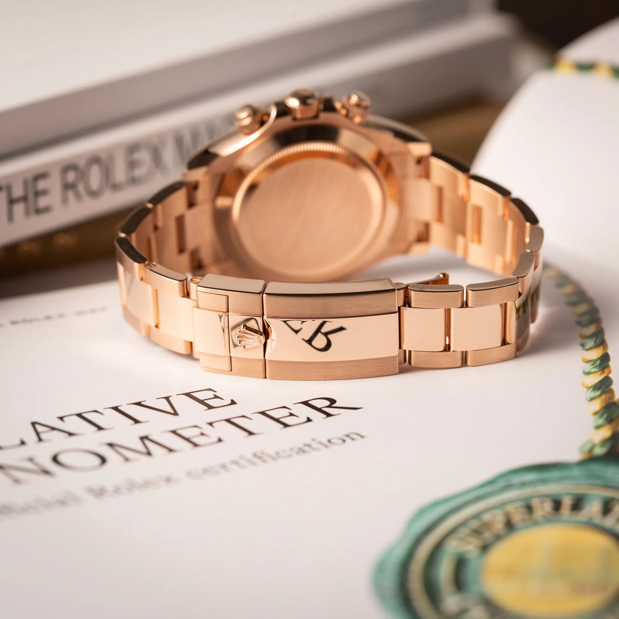 Produktfotografie zeigt die geschlossene Faltschliesse der Rolex Daytona Chronograph-Armbanduhr der Referenz 116505 in Everrose-Roségold mit schwarzem Zifferblatt am Oyster-Roségold-Band