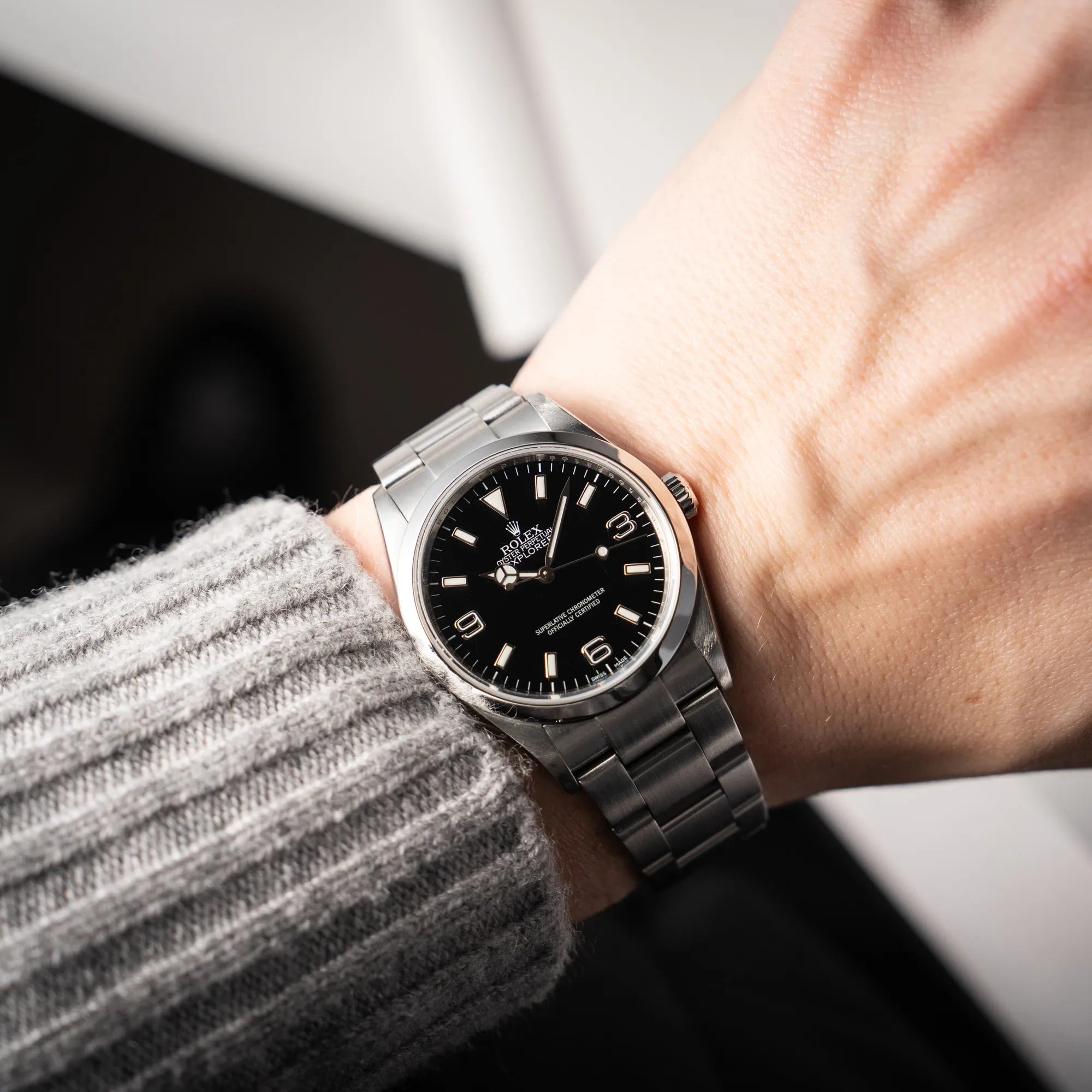 Mann präsentiert die Rolex Explorer 36 der Referenz 114270 mit dem klassischen schwarzen 3-6-9 Zifferblatt an seinem Handgelenk in die Kamera