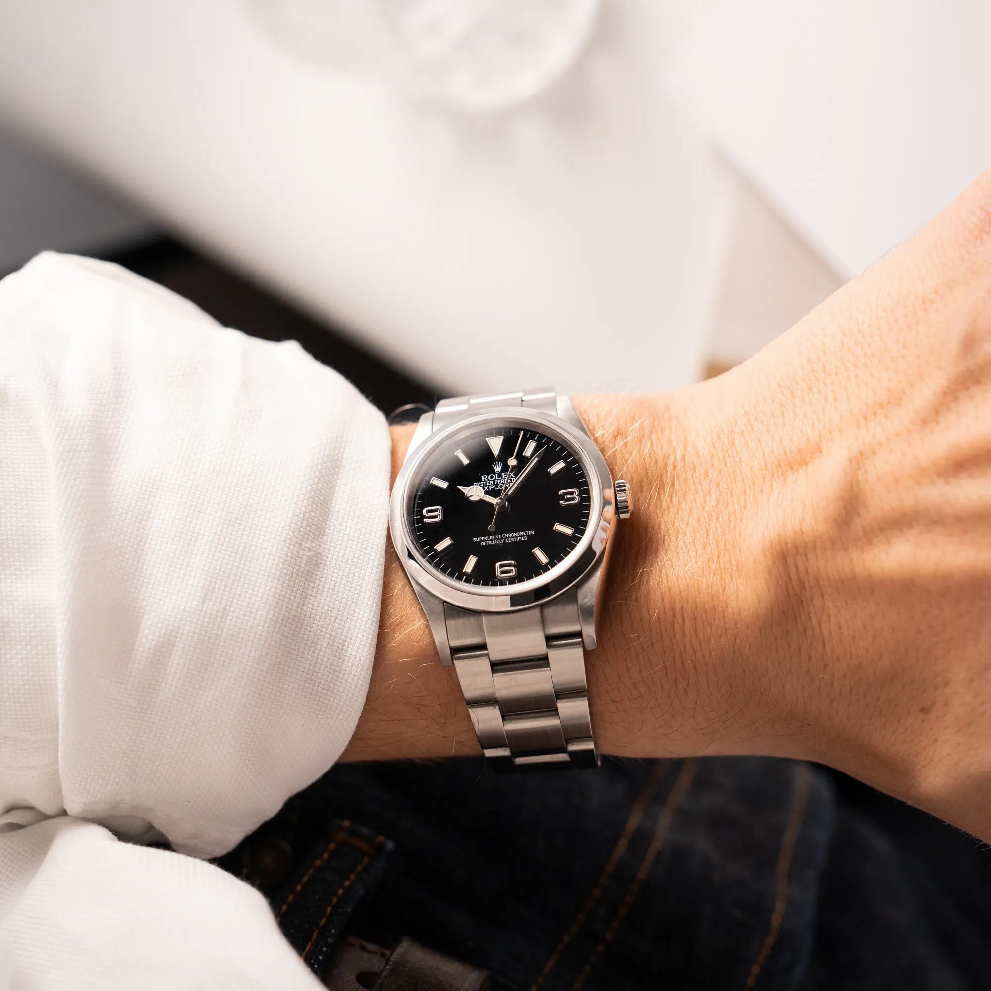 Mann trägt die Rolex Explorer 36 der Referenz 114270 mit dem klassischen schwarzen 3-6-9-Explorer-Zifferblatt am Oyster-Stahlband an seinem Handgelenk