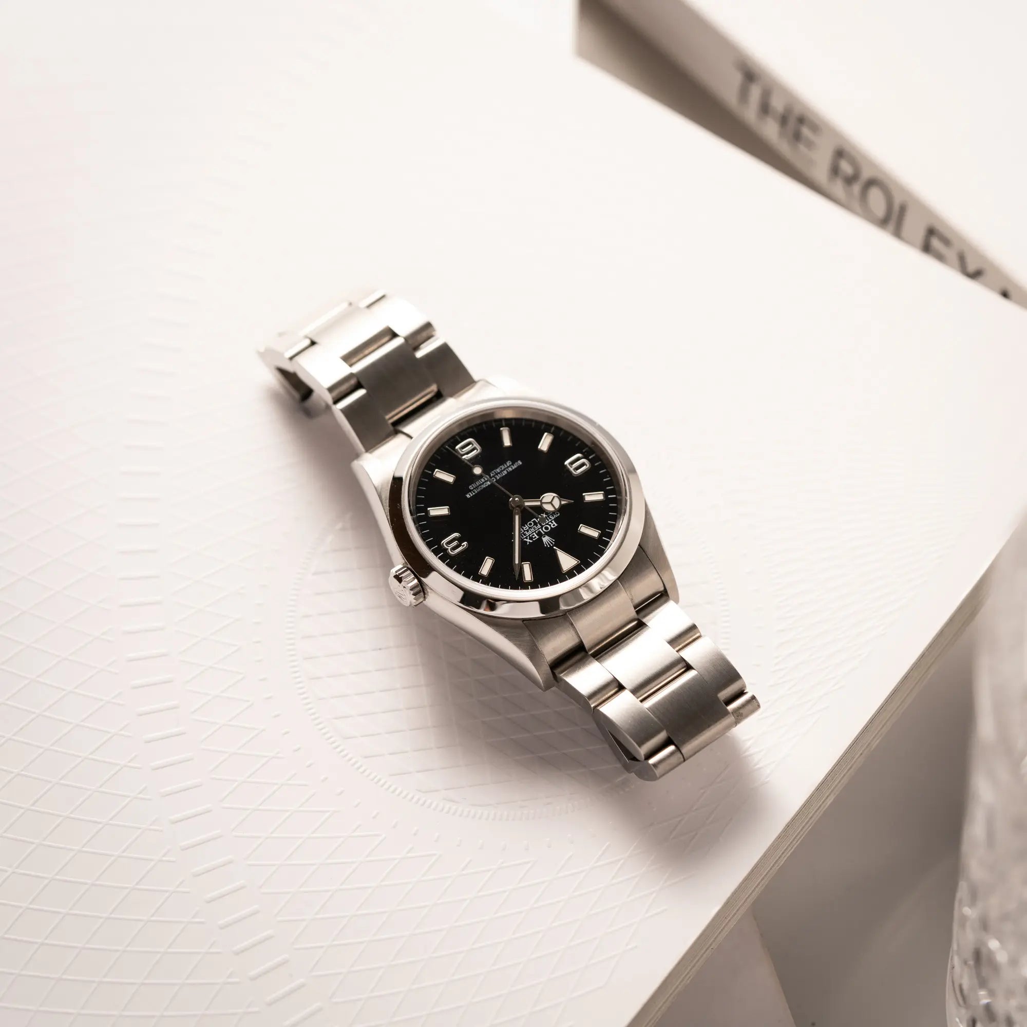 Rolex Explorer 36 der Referenz 114270 mit dem klassischen schwarzen 3-6-9-Explorer-Zifferblatt am Oytser-Stahlband liegt flach auf dem uhrearmband