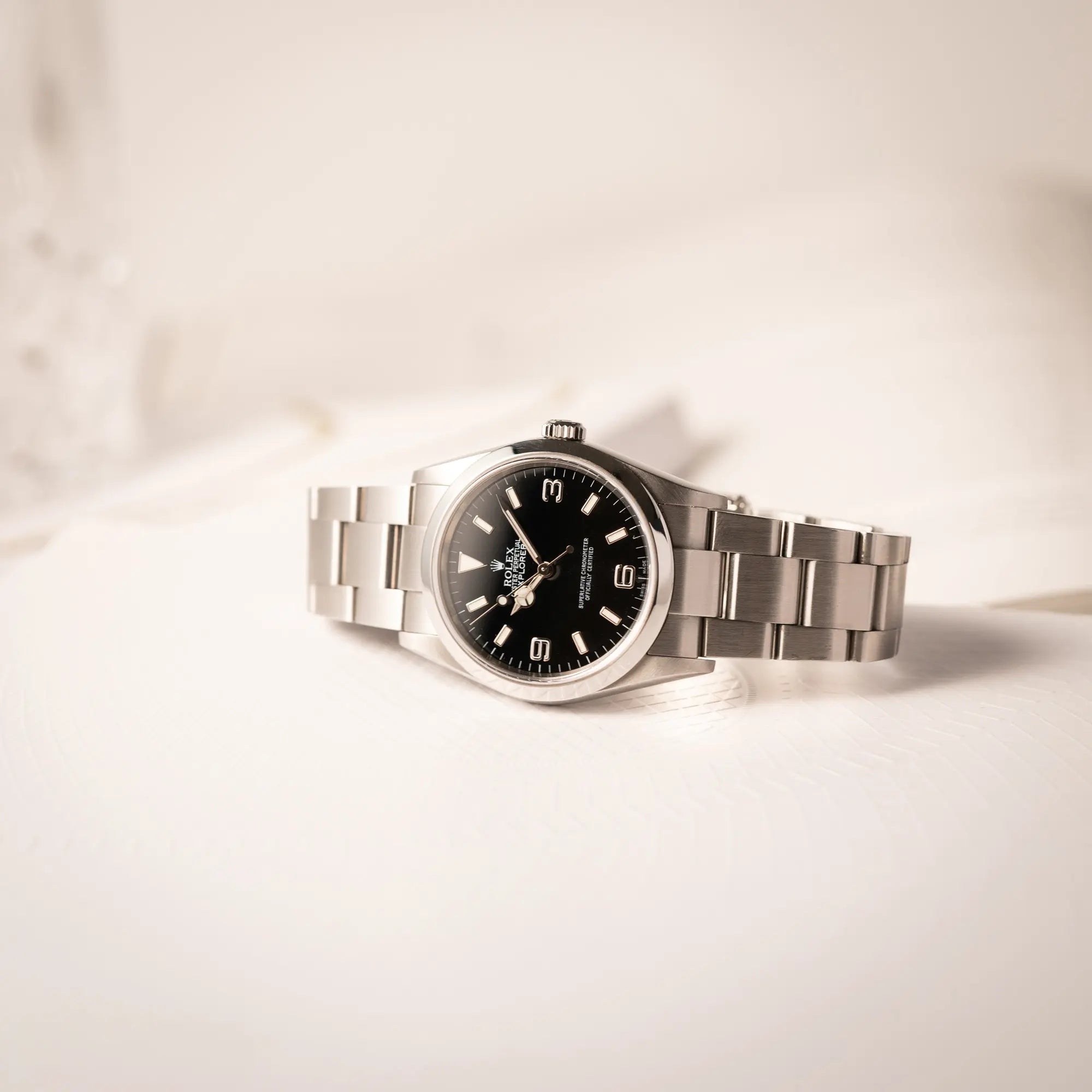 Produktfoto von der Rolex Explorer 36 der Referenz 114270 mit dem klassischen schwarzen 3-6-9-Explorer-Zifferblatt am Oytser-Stahlband