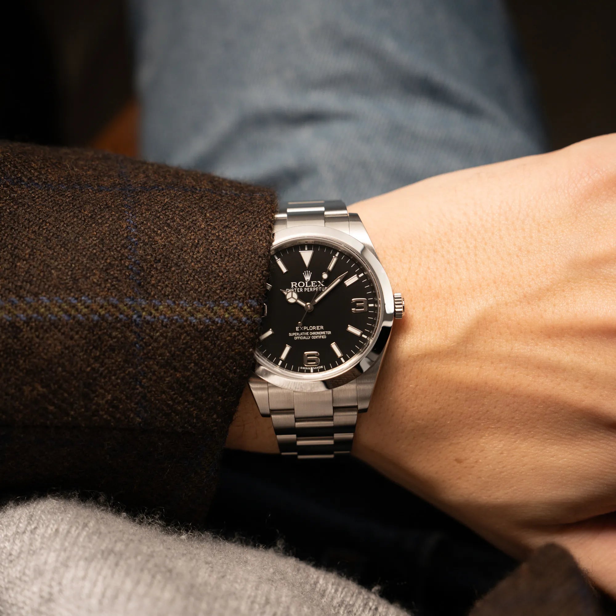 Mann trägt die Rolex Explorer der Referenz 214270 mit 39mm Oyster-Gehäuse und dem klassischen 2-6-9-Zifferblatt in schwarz für einen Wristshot an seinem Handgelenk