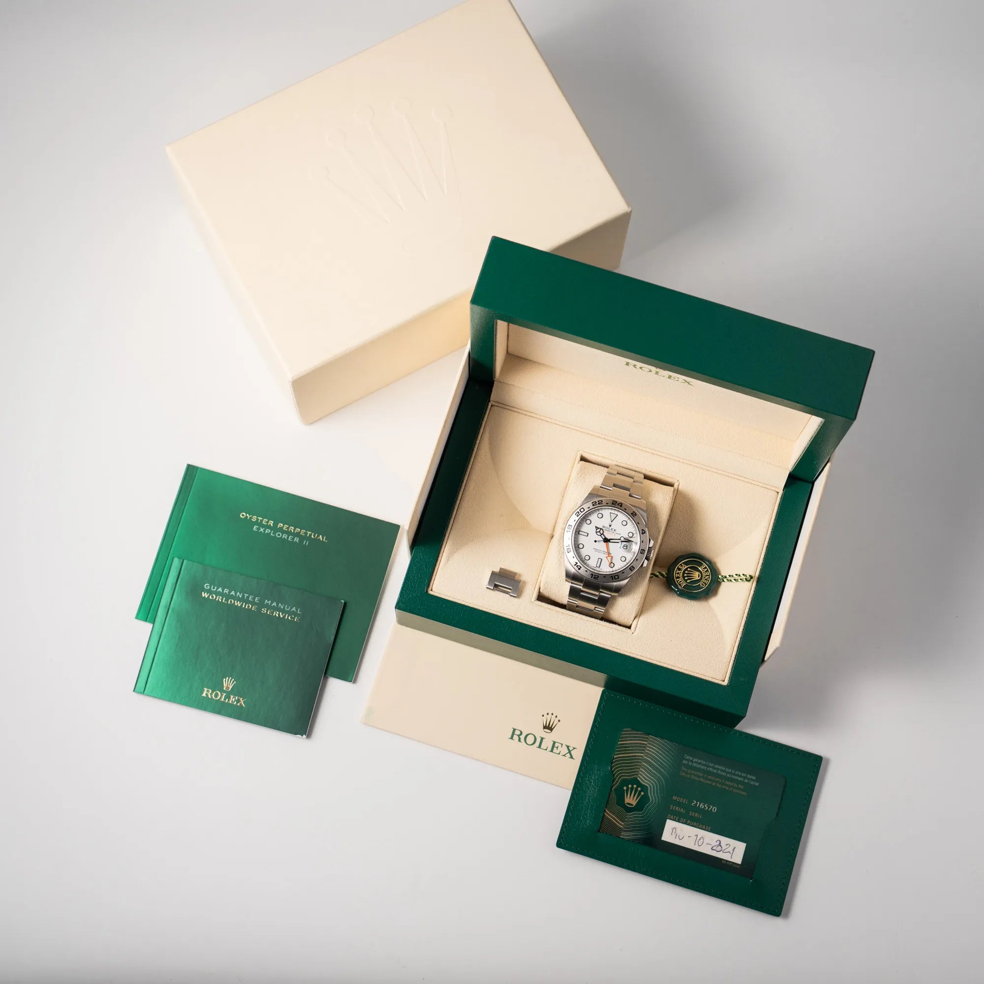 Lieferumfang zugehörig zu der Rolex Explorer II 216570 aus 2021 mit dem weißen Polar Zifferblatt mit dem typischen orangen GMT-Zeiger in einem sehr guten Zustand, bestehend aus Box mit Umkarton, originaler Garantiekarte, Hangtag und allen Booklets