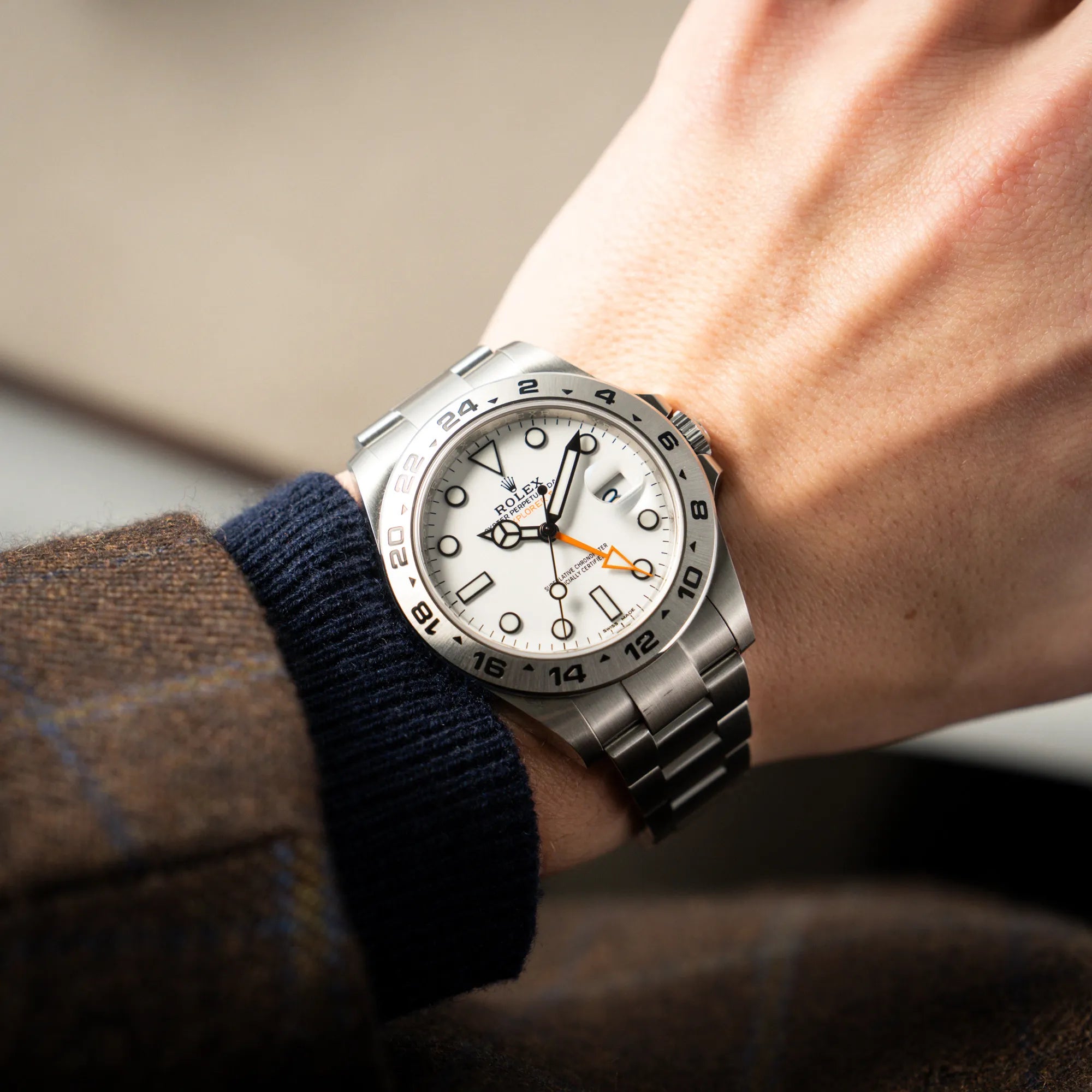 Mann trägt die Rolex Explorer II 216570 aus 2021 mit dem weißen Polar Zifferblatt mit dem typischen orangen GMT-Zeiger in einem sehr guten Zustand
